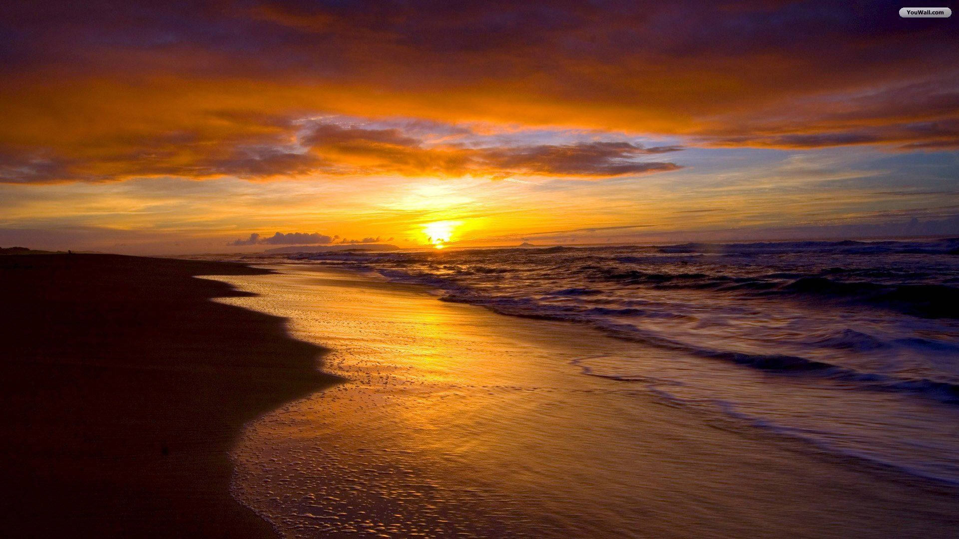 Tumblr Sunset Desktop 桌布 壁紙 — 令人嘆為觀止的日落將海洋和海灘染成火熱的橙色和深紫色調，海浪輕輕拍打著海岸。