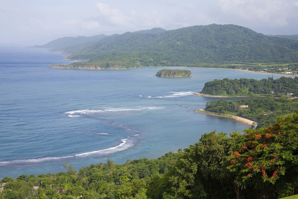 Jamaican Island 桌布 壁紙 — 令人嘆為觀止的海岸景色，碧綠的海水拍打著鬱鬱蔥蔥的綠色山丘和遠處的一個小島。