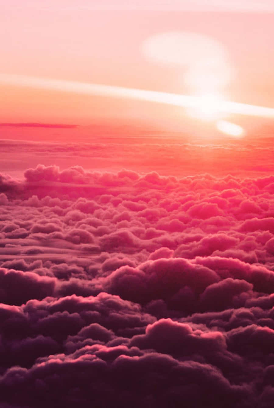 雲朵 桌布 壁紙 — 令人嘆為觀止的空中景觀，蓬鬆的雲朵沐浴在鮮豔的粉紅色和橙色色調中，太陽在上方落下。