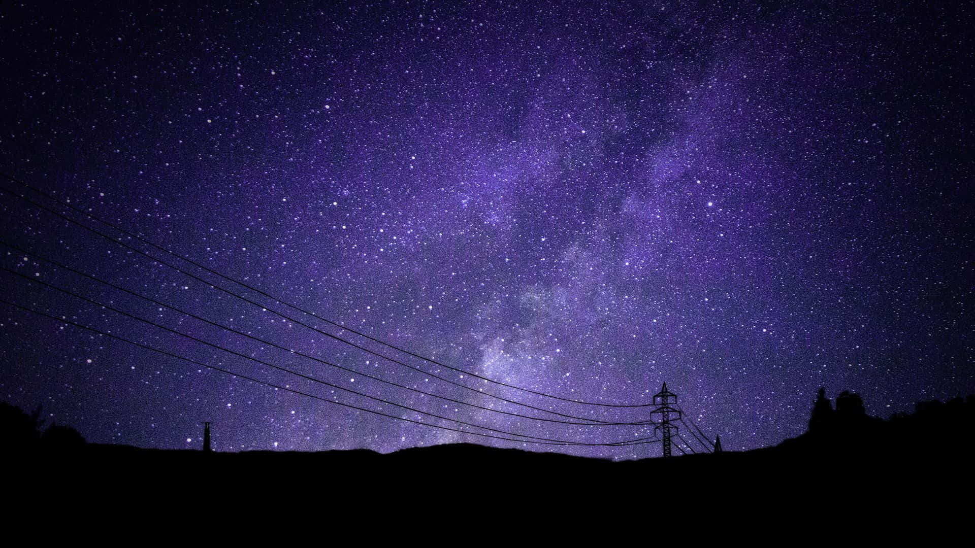 Galaxy Sky 桌布 壁紙 — 令人嘆為觀止的紫色夜空，佈滿星星，銀河在黑暗的山丘和電線輪廓上拱起。