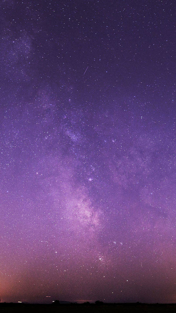 紫色夜空 桌布 壁紙 — 令人嘆為觀止的紫色夜空，繁星點點，銀河在黑暗的地平線上拱起。