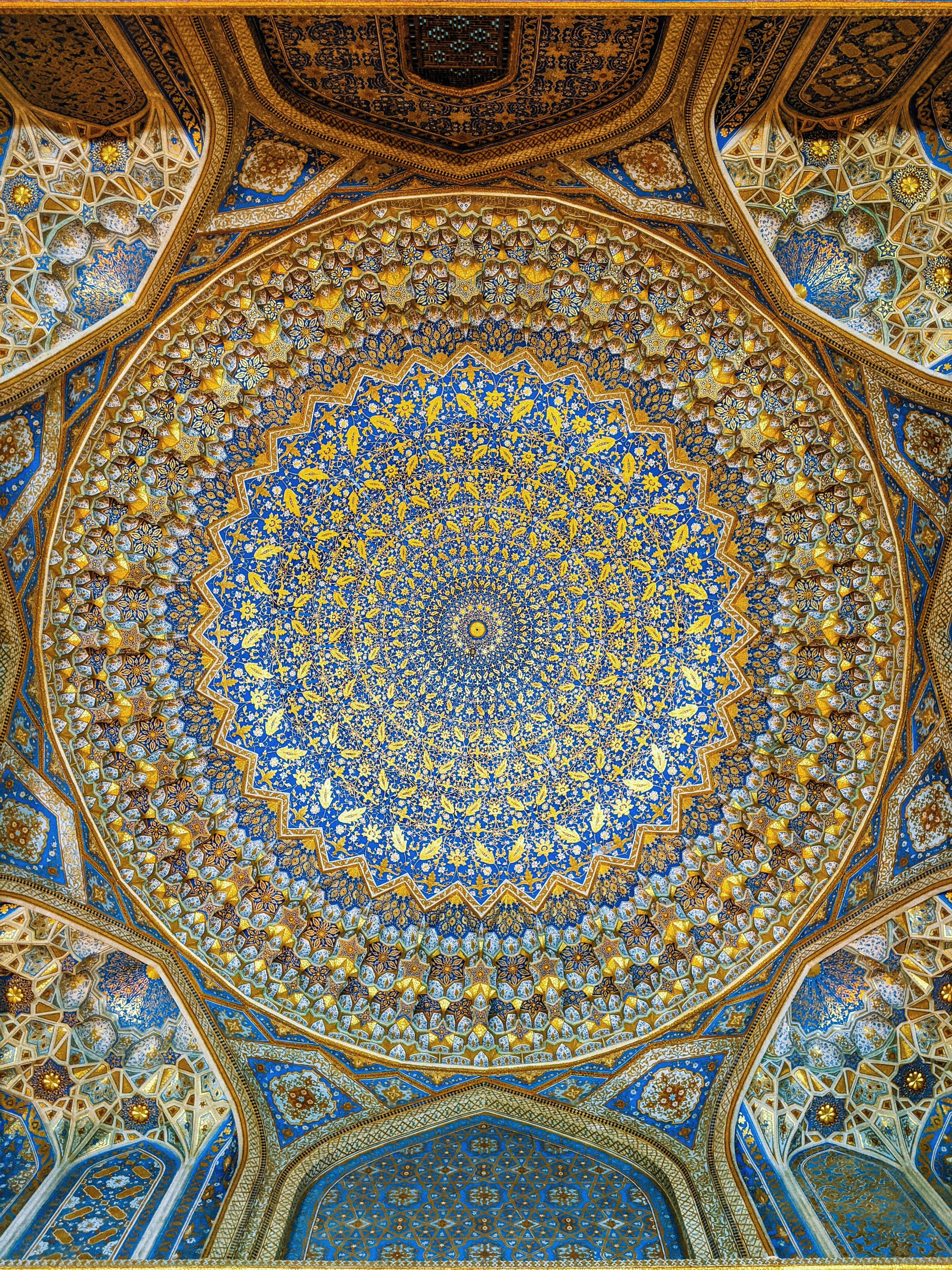 Uzbekistan 桌布 壁紙 — 令人嘆為觀止的藍金伊斯蘭圓頂天花板，從中心點輻射出對稱的幾何和花卉圖案。