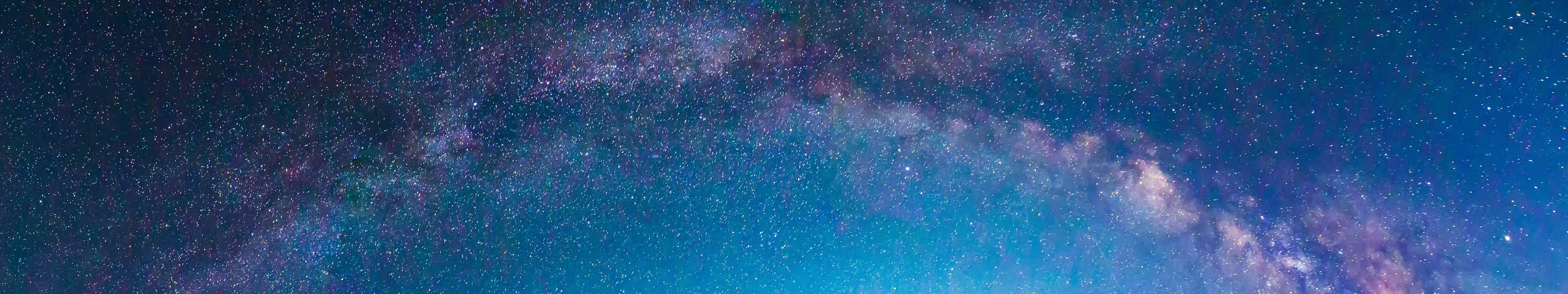 桌布 壁紙 — 令人嘆為觀止的銀河系全景，在繁星點點的夜空中閃耀著鮮豔的藍色和紫色。