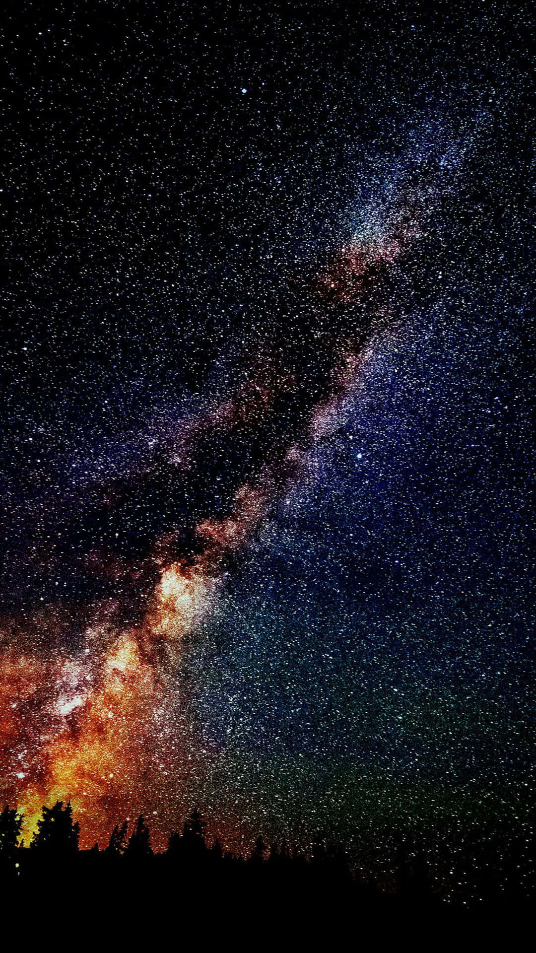 iPhone Home Screen 桌布 壁紙 — 令人嘆為觀止的銀河系在繁星點點的夜空上拱起，下方是黑暗的森林輪廓。
