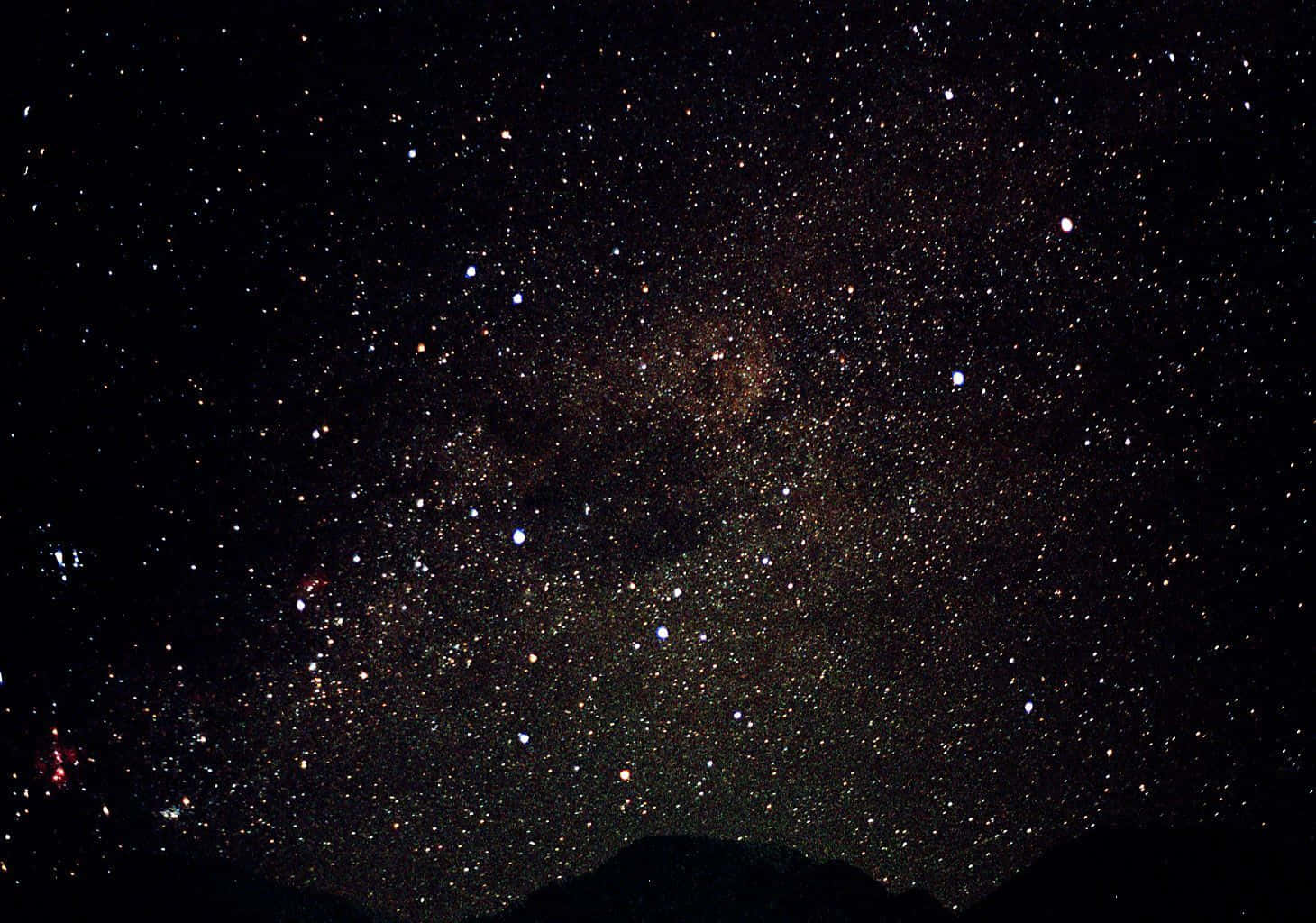 桌布 壁紙 — 令人嘆為觀止的銀河系景色，無數星星在黑暗的山巒輪廓上方閃耀。