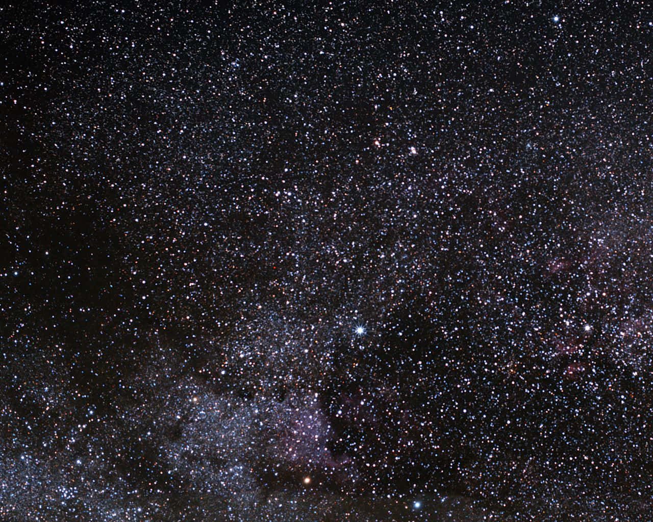 Stars 桌布 壁紙 — 令人嘆為觀止的銀河系景觀，充滿無數恆星和發光的宇宙塵埃雲，映襯著深邃的黑色天空。