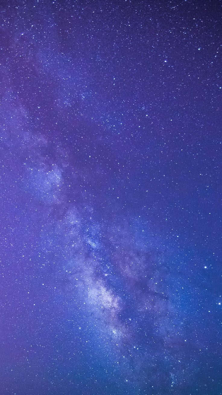 Galaxy Blue Aesthetic 桌布 壁紙 — 令人嘆為觀止的銀河系景觀，在佈滿星星的夜空中散發著紫色和藍色的光芒。