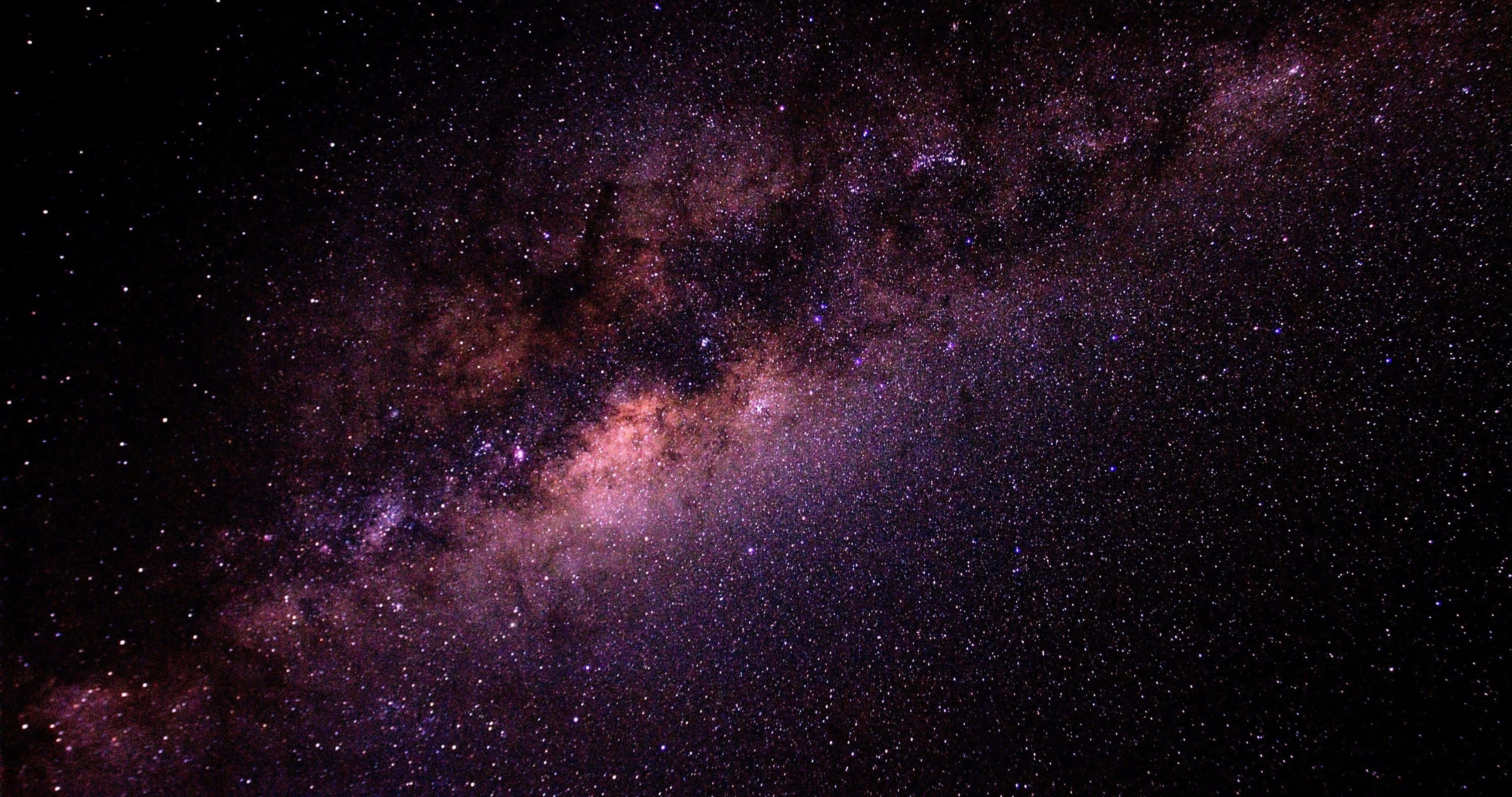 Beautiful Galaxy 桌布 壁紙 — 令人嘆為觀止的銀河系景觀，在深邃的黑色天空中閃耀著鮮豔的紫色和粉紅色。