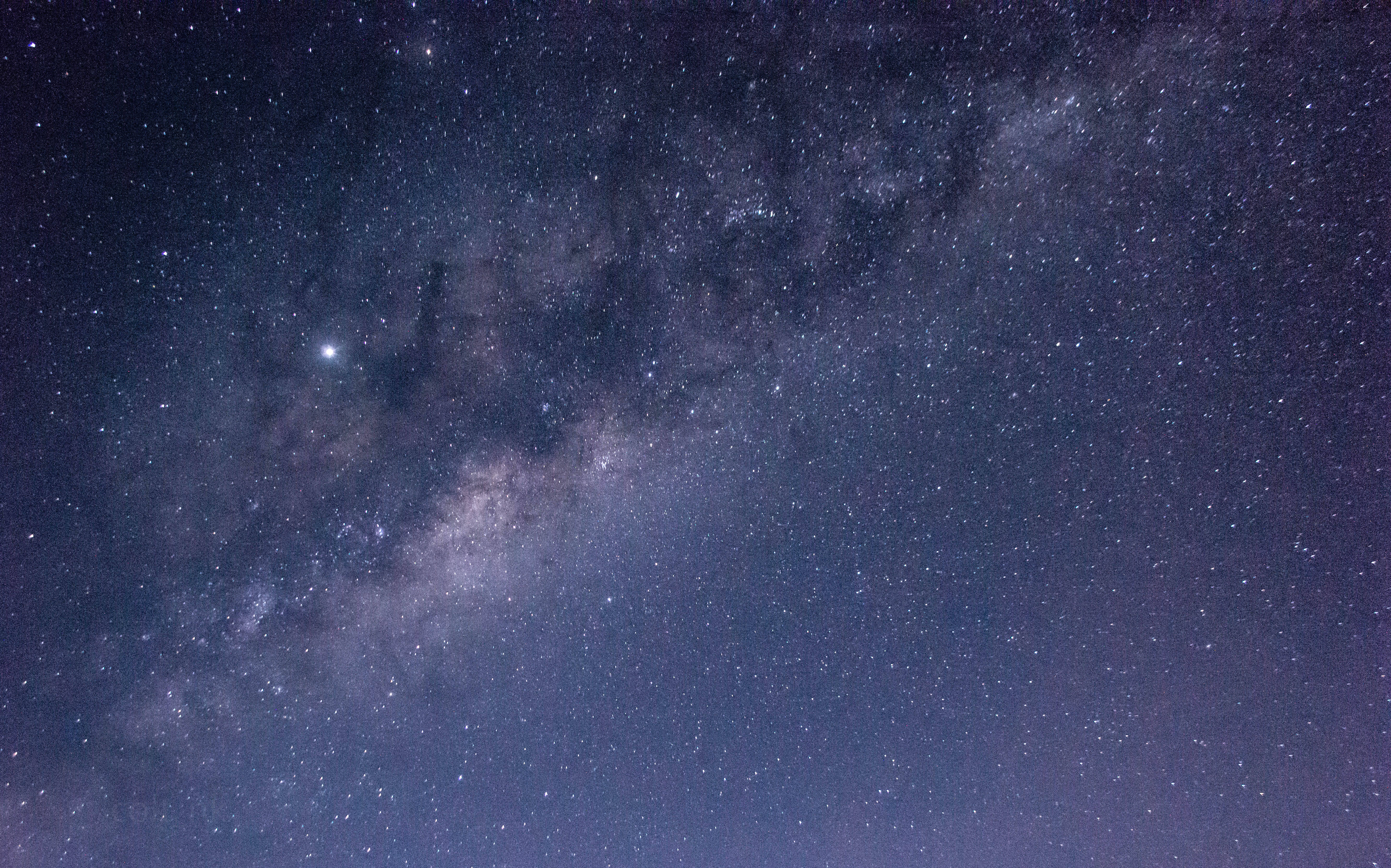 宇宙美學 桌布 壁紙 — 令人嘆為觀止的銀河系景觀，在深靛藍色的夜空中閃爍著無數的星星和宇宙塵埃。