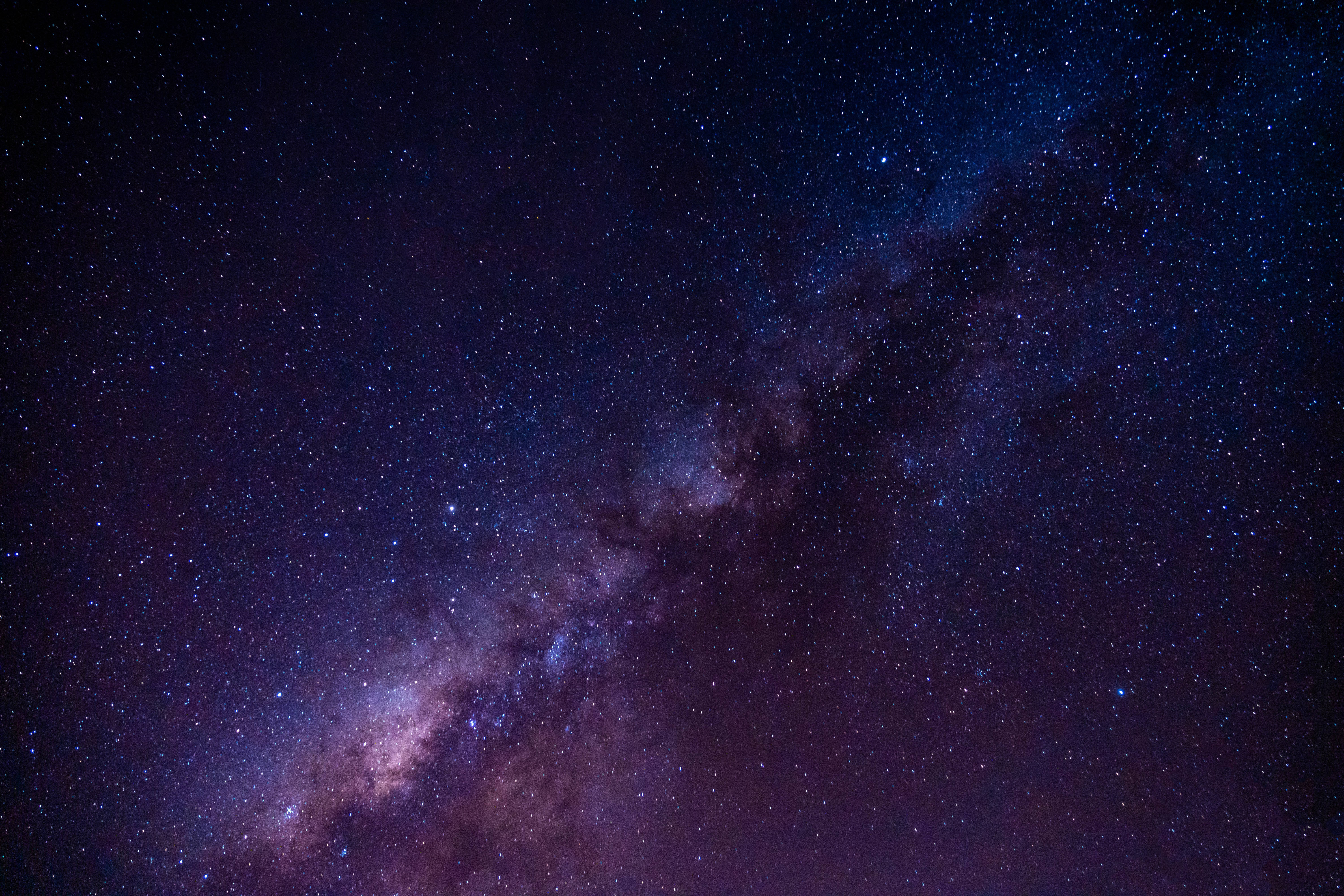 Milky 桌布 壁紙 — 令人嘆為觀止的銀河系景觀，在繁星點點的夜空中散發著紫色和藍色的光芒。