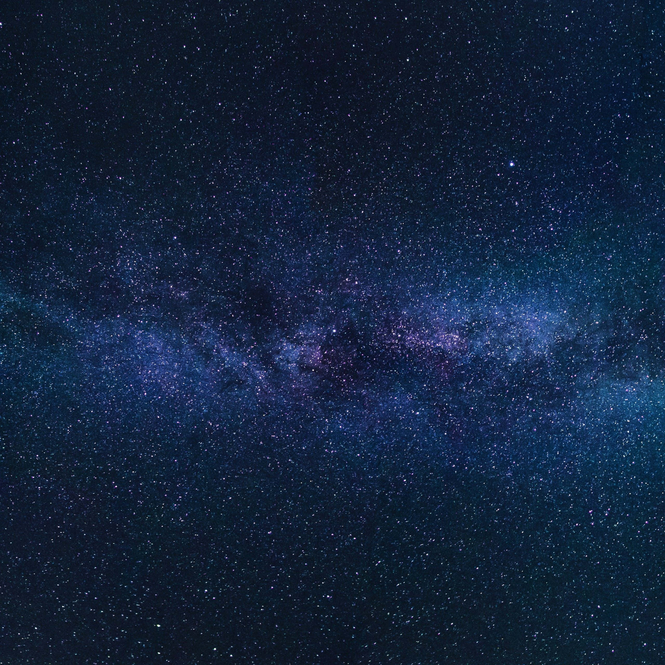 Star Sky 桌布 壁紙 — 令人嘆為觀止的銀河系景觀，在繁星點點的夜空中散發著紫色和藍色的光芒。