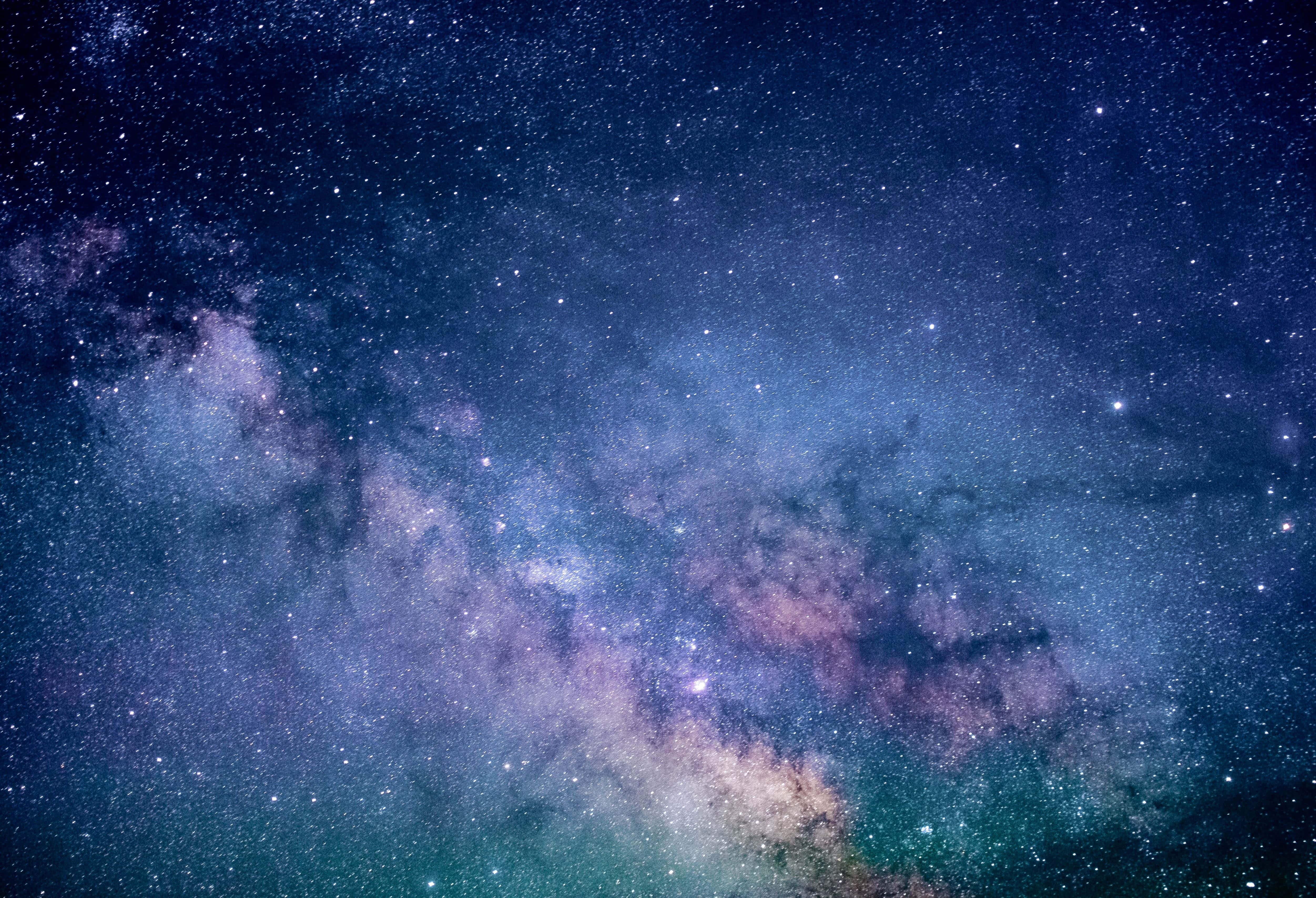 Celestial 桌布 壁紙 — 令人嘆為觀止的銀河系景觀，在繁星點點的夜空中散發出充滿活力的紫色和藍綠色光芒。