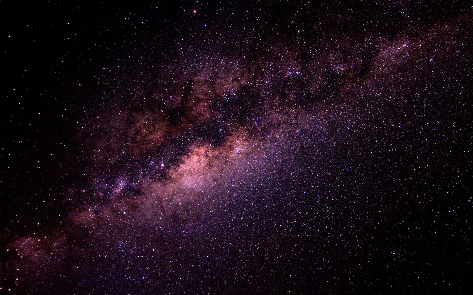 High Resolution Galaxy 桌布 壁紙 — 令人嘆為觀止的銀河系景觀，在繁星點綴的黑色天空中散發著鮮豔的紫色和粉紅色光芒。