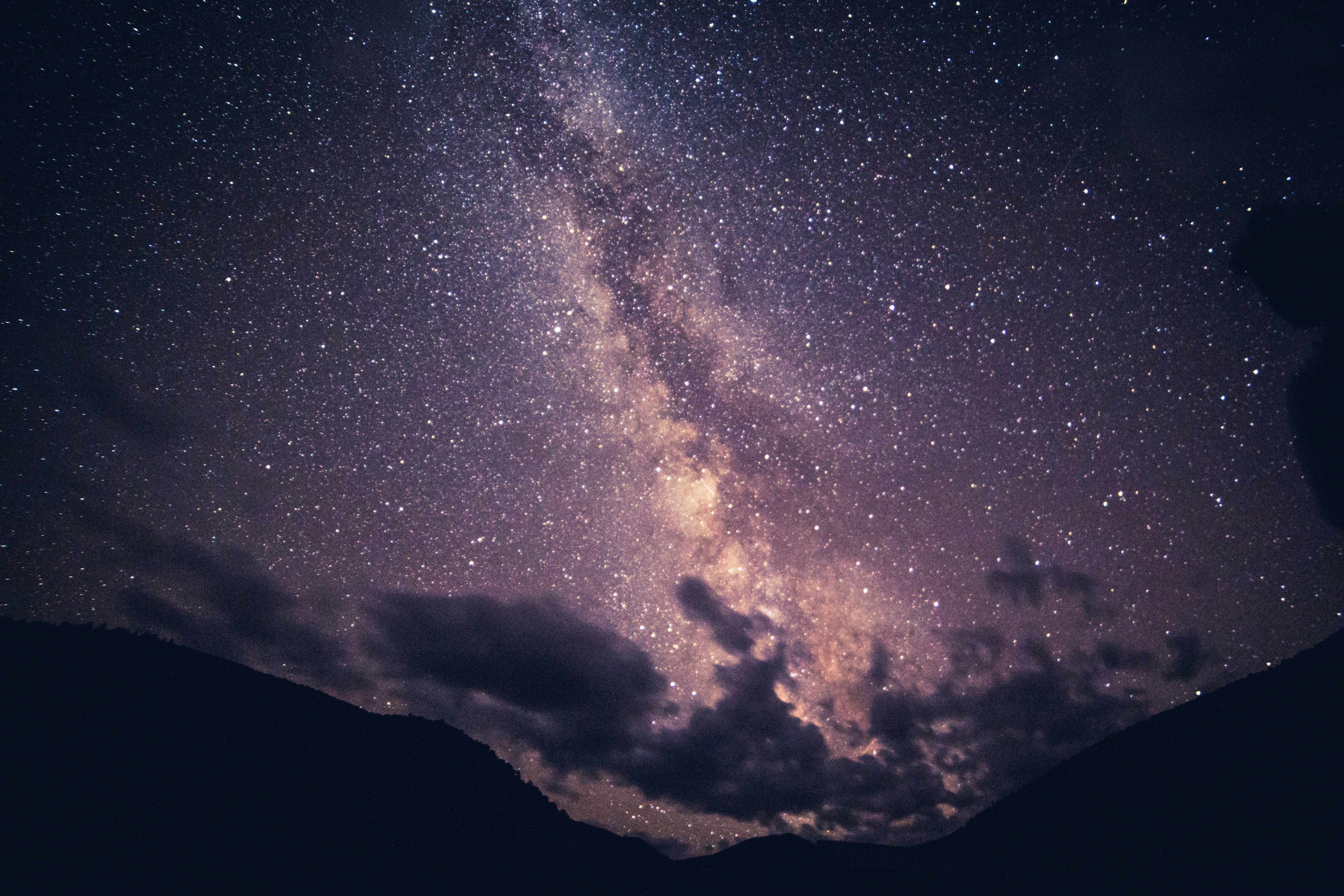 Milky 桌布 壁紙 — 令人嘆為觀止的銀河系景觀，在黑暗山巒剪影上方，橫跨繁星點點的夜空。