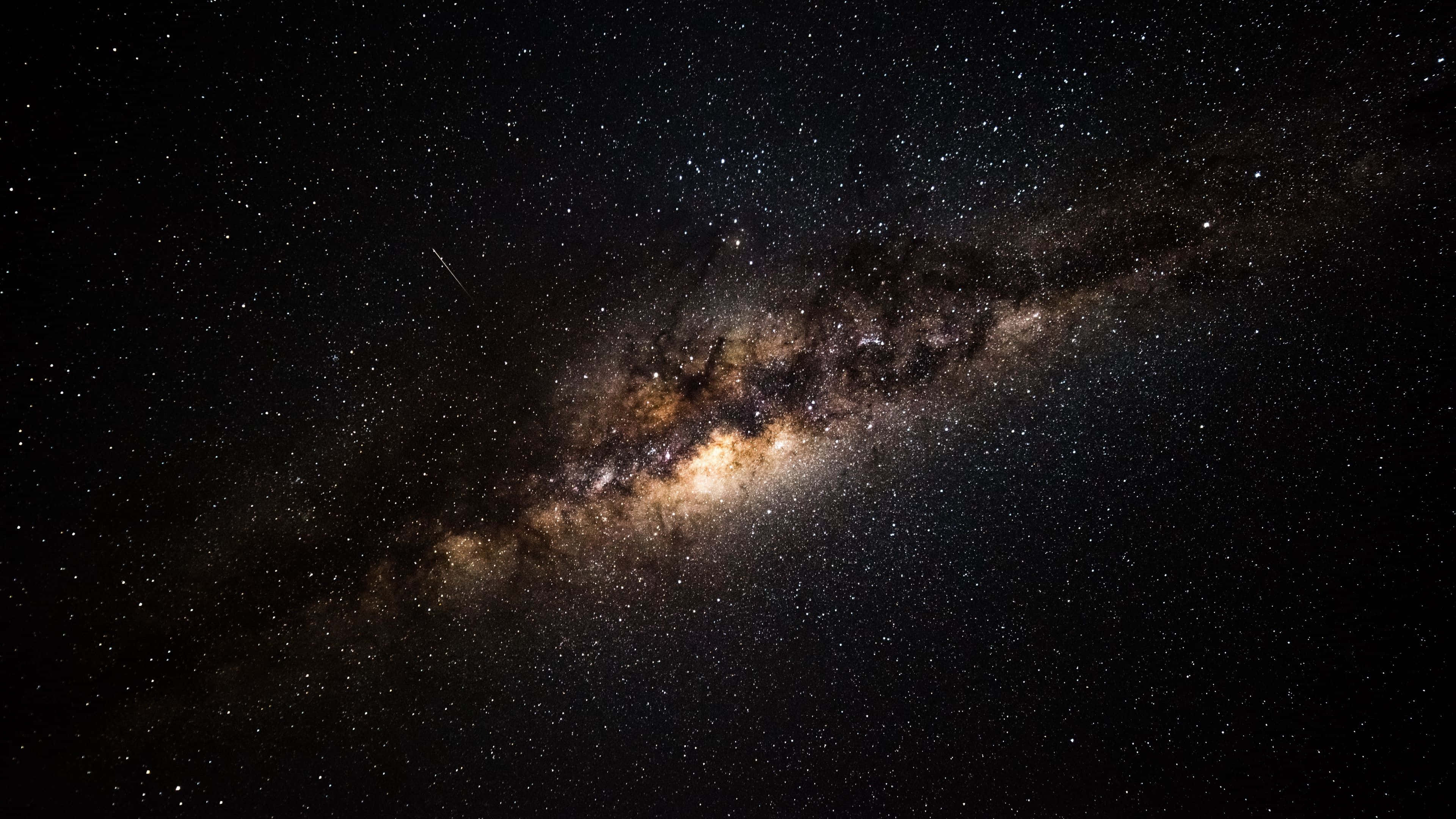 Black Galaxy 桌布 壁紙 — 令人嘆為觀止的銀河系景觀，橫跨佈滿星星的夜空，帶有發光的星雲和宇宙塵埃。