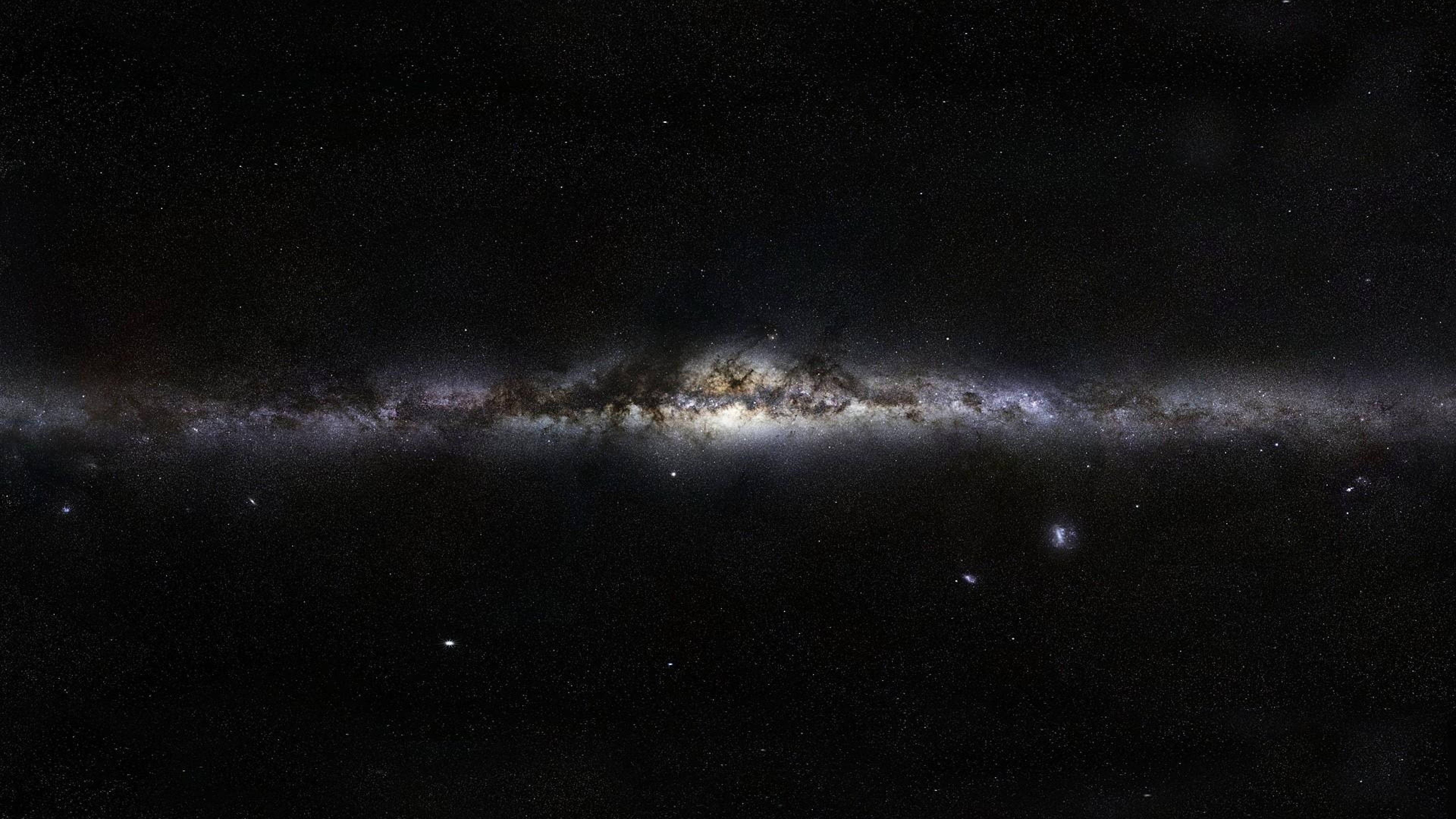 4K 太空 桌布 壁紙 — 令人嘆為觀止的銀河系景觀，橫跨佈滿星辰的宇宙虛空，帶有發光的星雲和黑暗的塵埃帶。