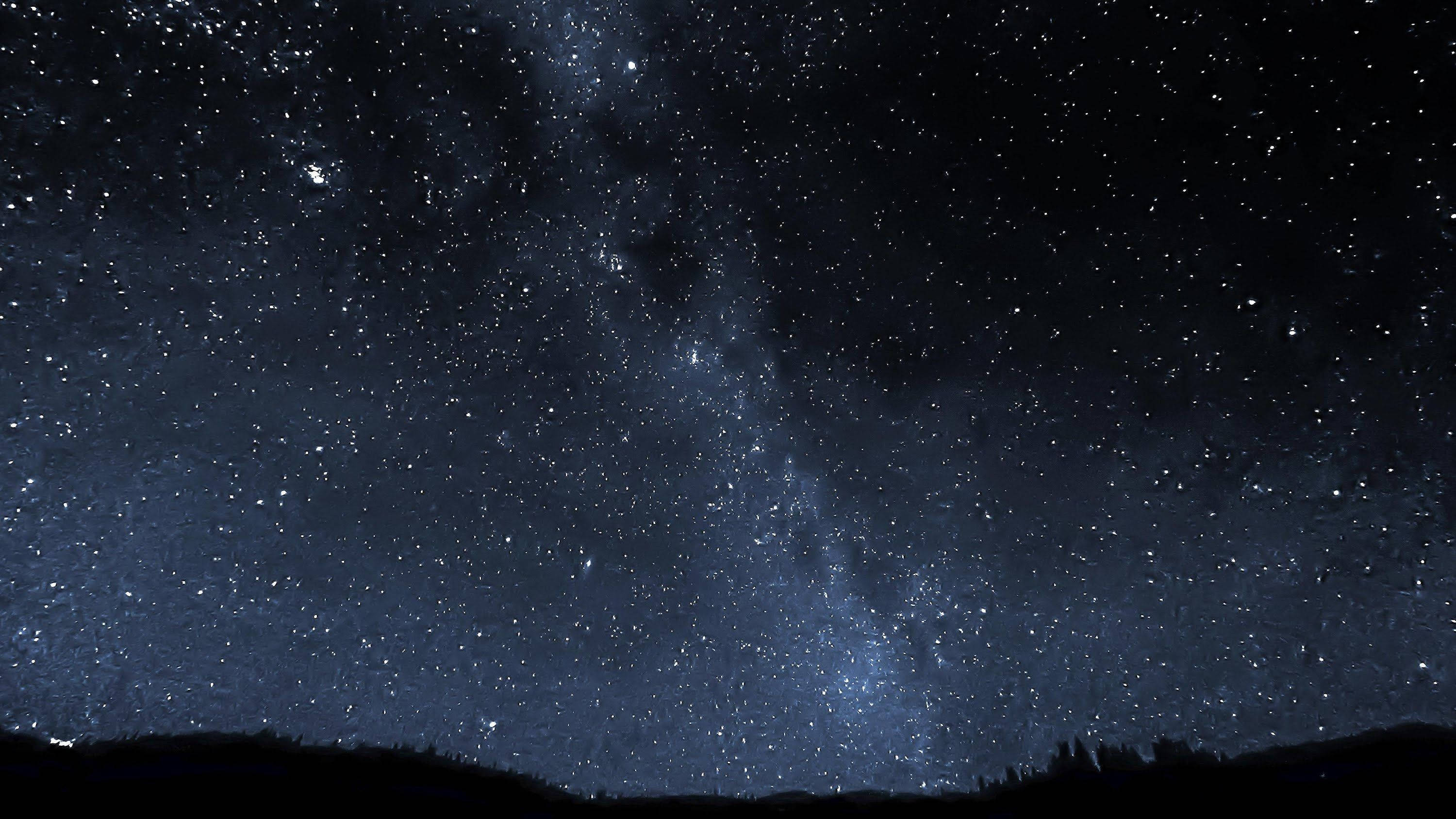 夜空 桌布 壁紙 — 令人嘆為觀止的銀河系景觀，無數星星在黑暗的山脈剪影上方閃耀。
