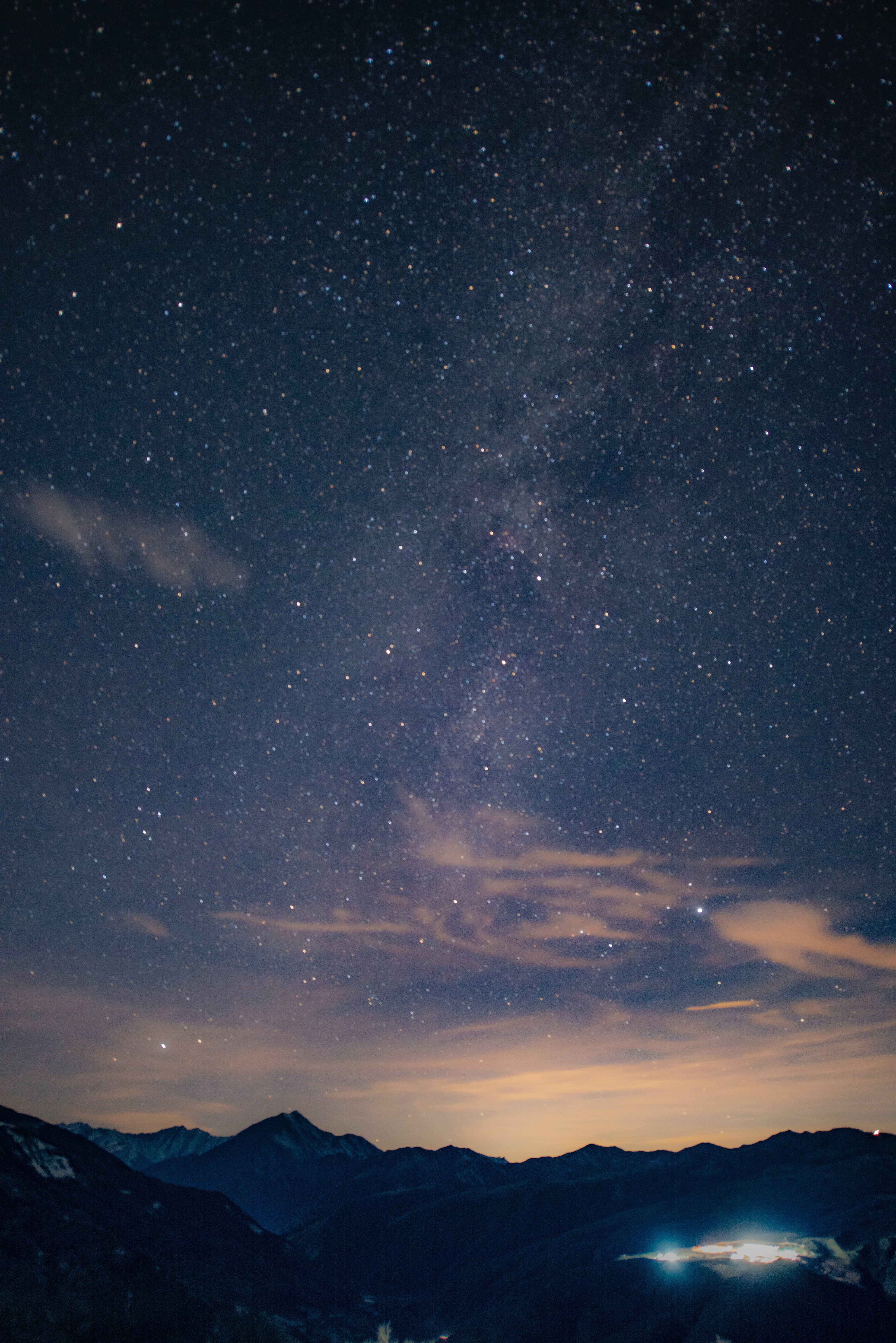 夜空 桌布 壁紙 — 令人屏息的夜空，佈滿無數星辰，銀河在黑暗的山峰上空彎曲，下方是發光的山谷。