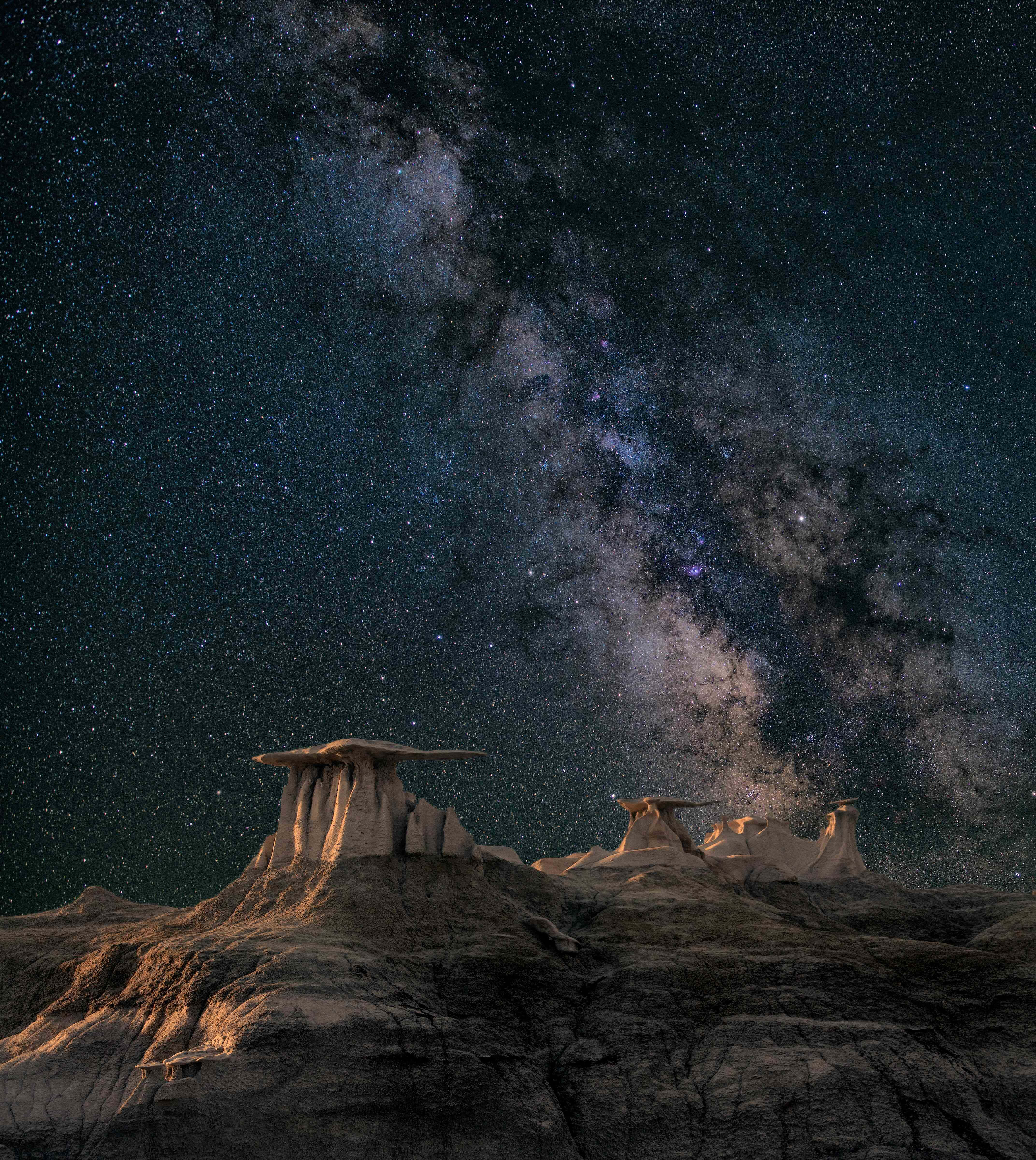 圖片 桌布 壁紙 — 令人屏息的夜空，滿天繁星與銀河拱跨在獨特的石林岩層之上。