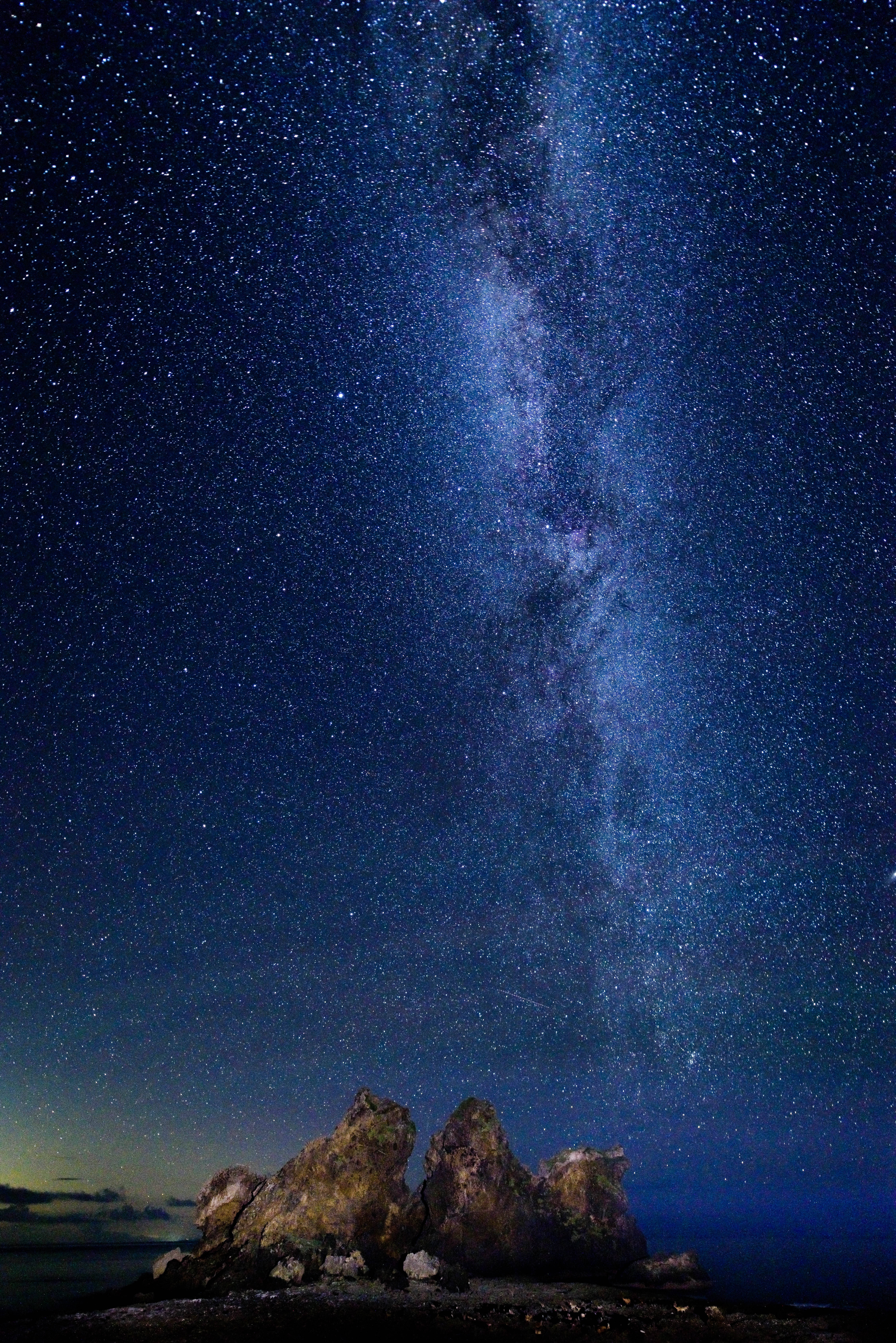 no way 桌布 壁紙 — 令人屏息的夜空佈滿無數星星，銀河戲劇性地拱起在崎嶇的海岸岩石上。