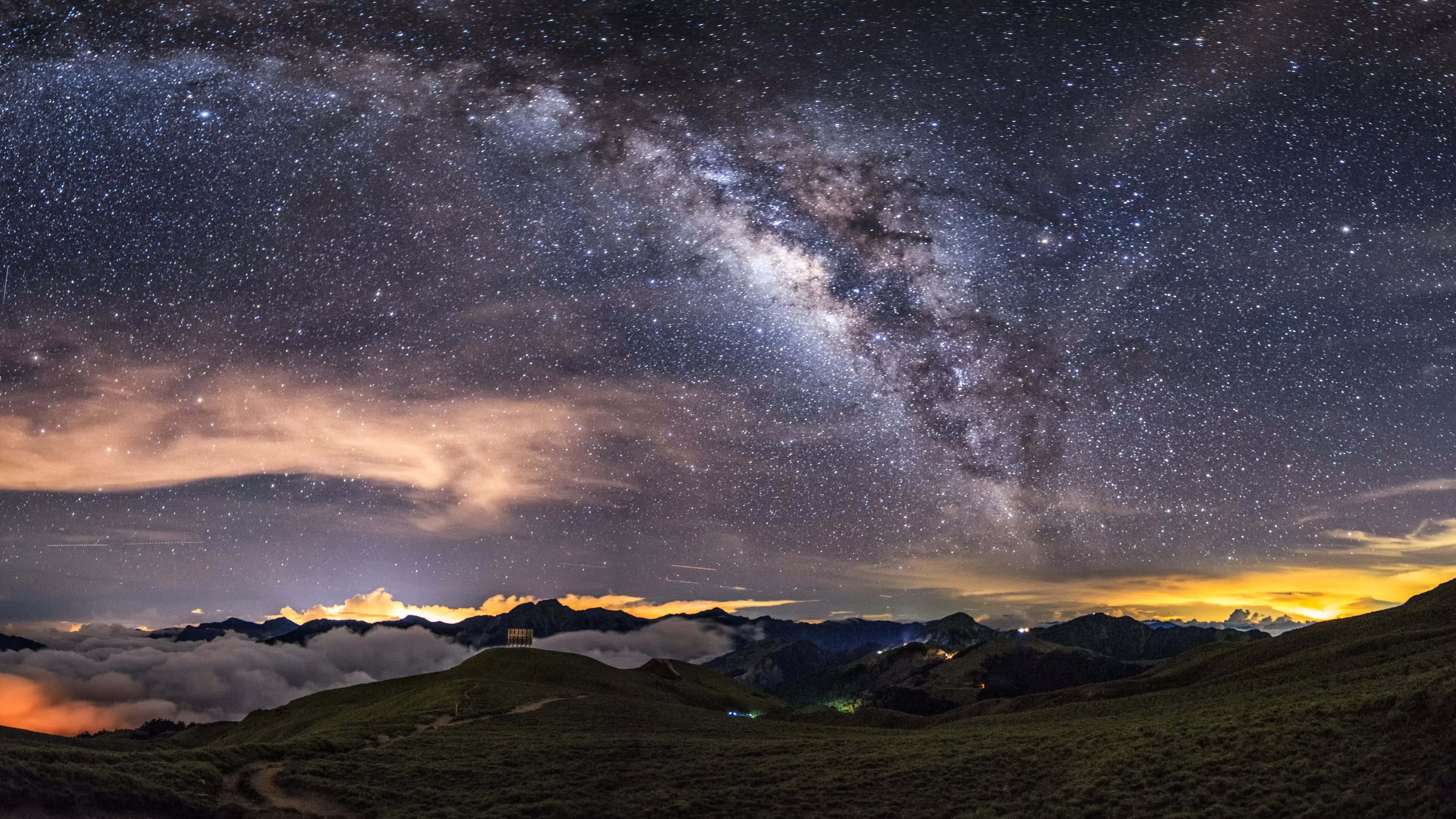 桌布 壁紙 — 令人屏息的夜空佈滿繁星，銀河在雲海之上的山脊拱起。