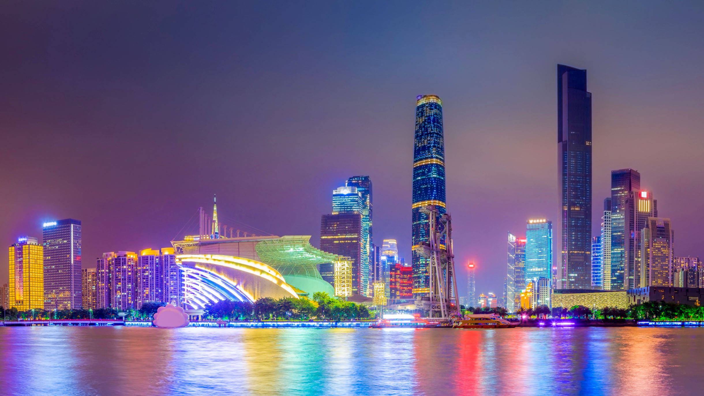 Guangzhou 桌布 壁紙 — 令人目眩的夜景城市景觀，高聳的摩天大樓在平靜的河面上反射出鮮豔的霓虹燈光。