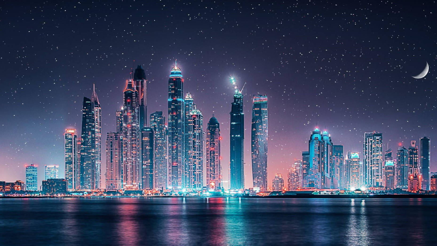 Arab 桌布 壁紙 — 令人眼花撩亂的城市天際線夜景，高聳的摩天大樓在星空和彎月下閃耀。