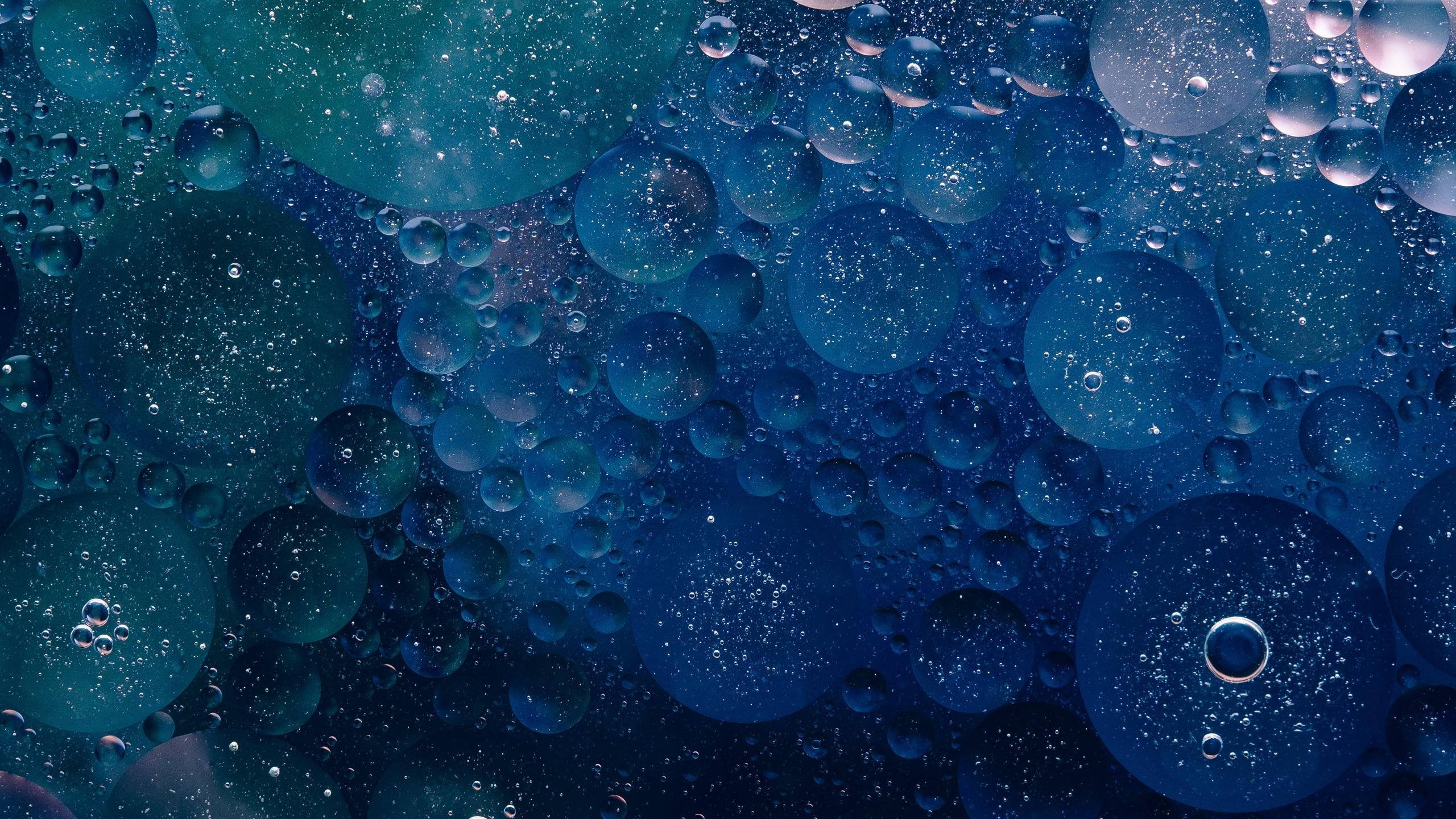 Blue Texture 桌布 壁紙 — 令人著迷的微距特寫，呈現帶有閃爍粒子的虹彩藍色油泡在水中漂浮。