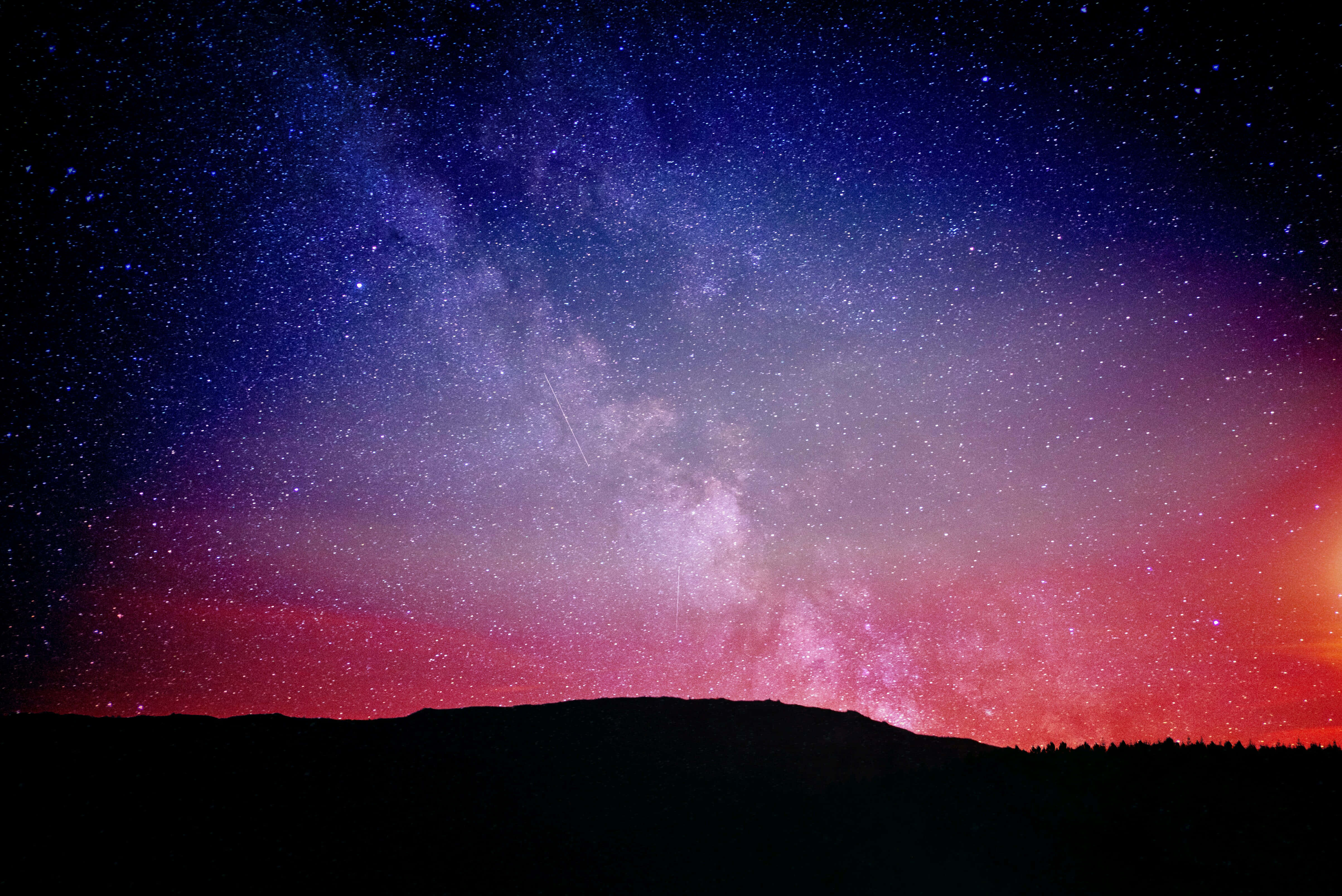 Starry Sky 桌布 壁紙 — 令人驚嘆的夜空，佈滿繁星，銀河在黑暗的山脈輪廓上彎曲。