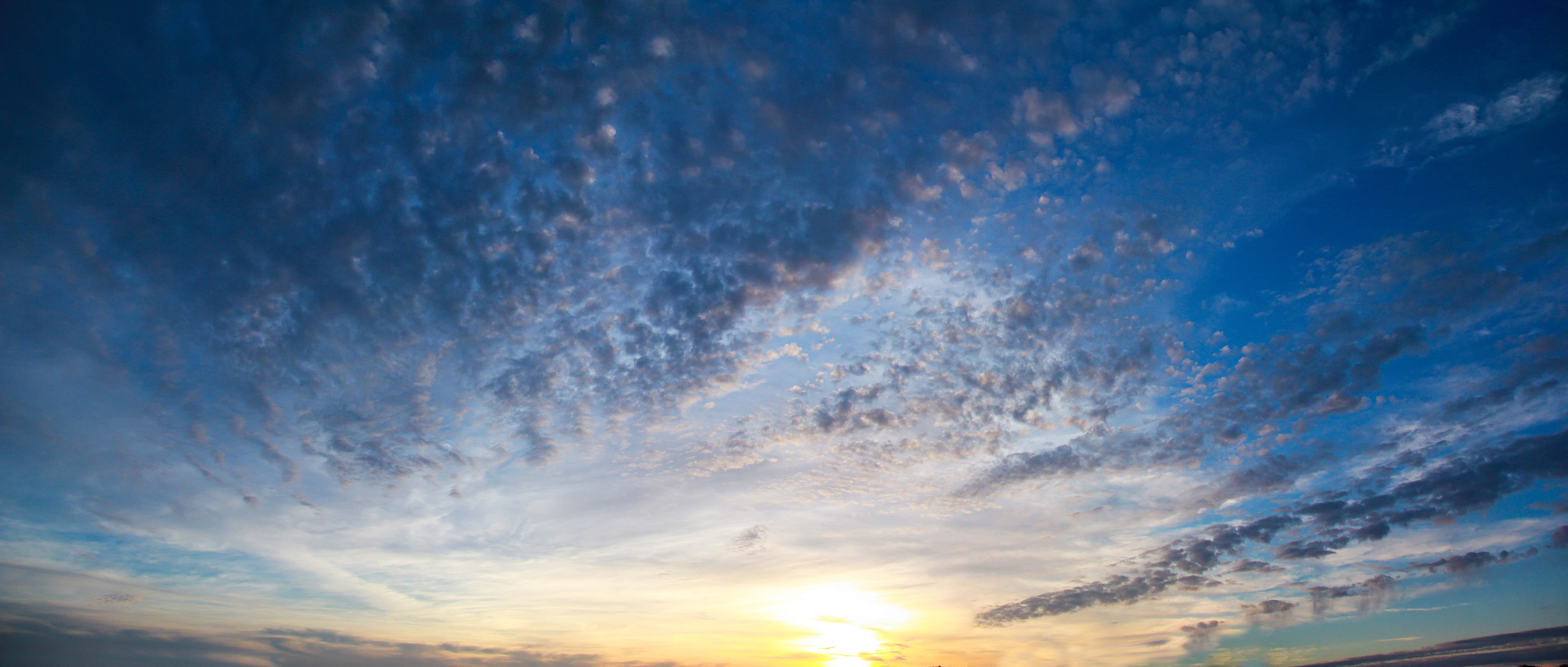 Hi Res Sky 桌布 壁紙 — 令人驚嘆的日出用金色光芒和柔和的藍色雲彩繪畫天空。