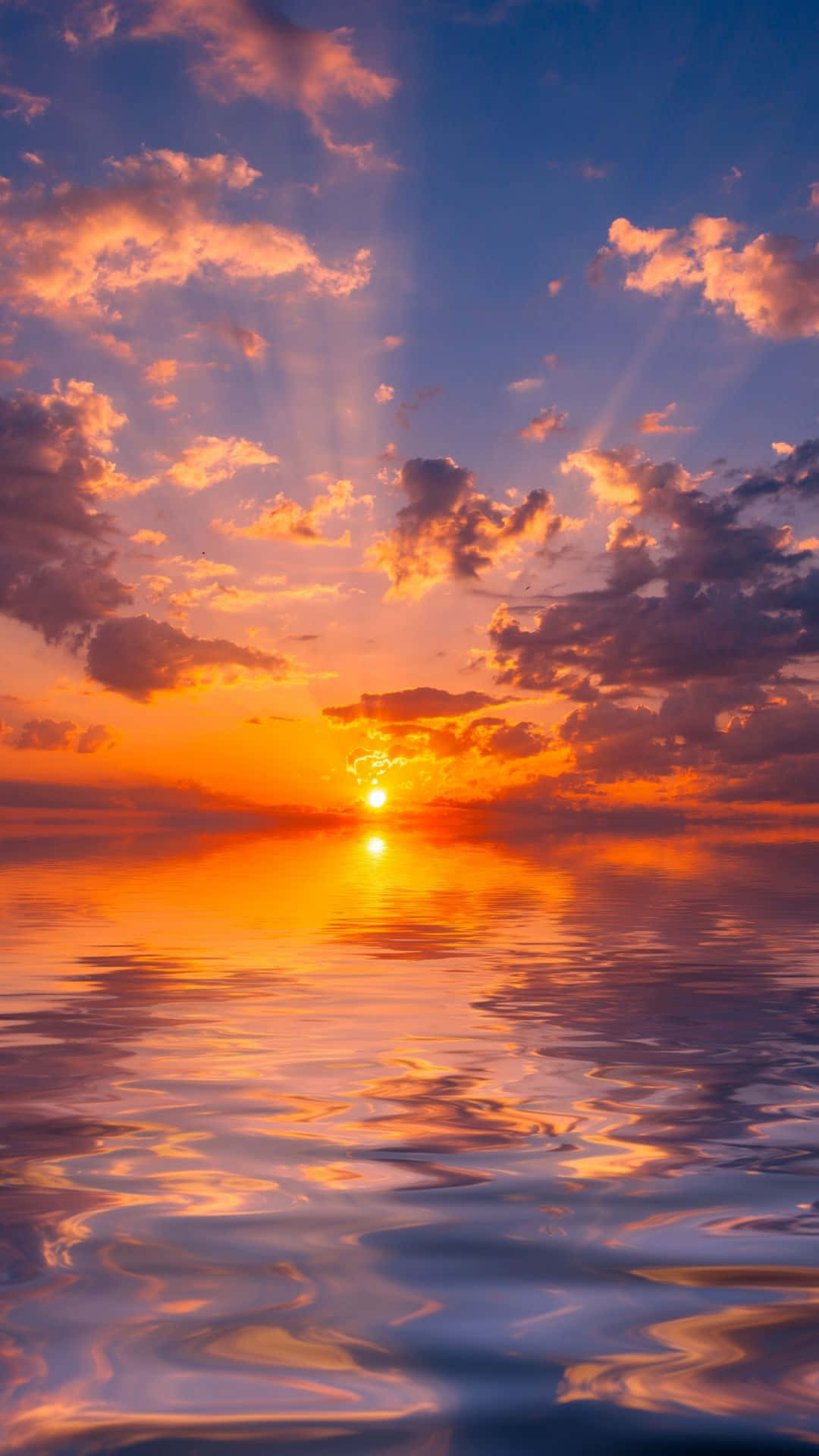Clouds Aesthetics 桌布 壁紙 — 令人驚嘆的日落，平靜的水面上，燦爛的橙色陽光穿透紫色和粉紅色的雲層。