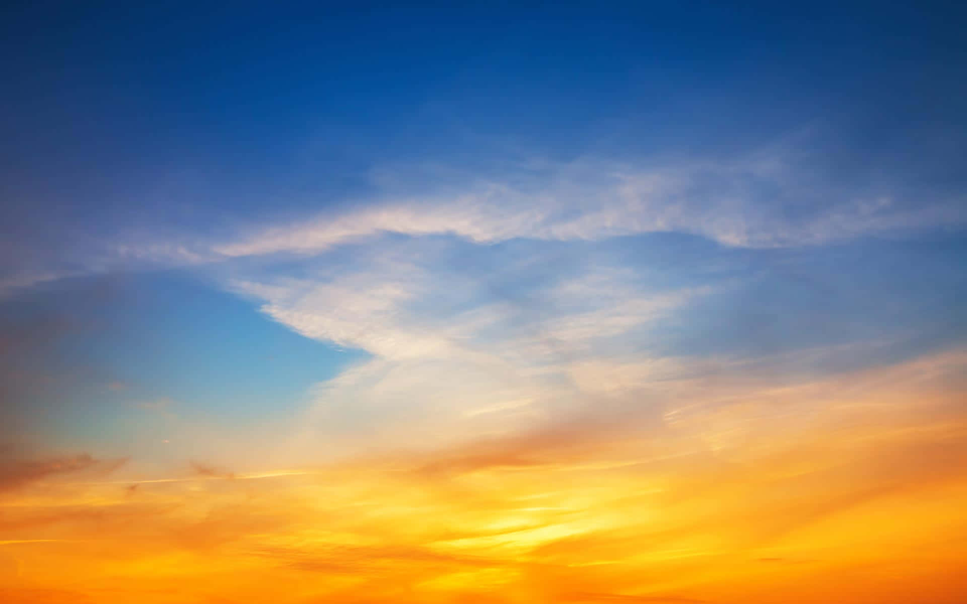 Beautiful Sky 桌布 壁紙 — 令人驚嘆的日落天空，鮮豔的橙色和黃色色調在薄雲之上融入深藍色。