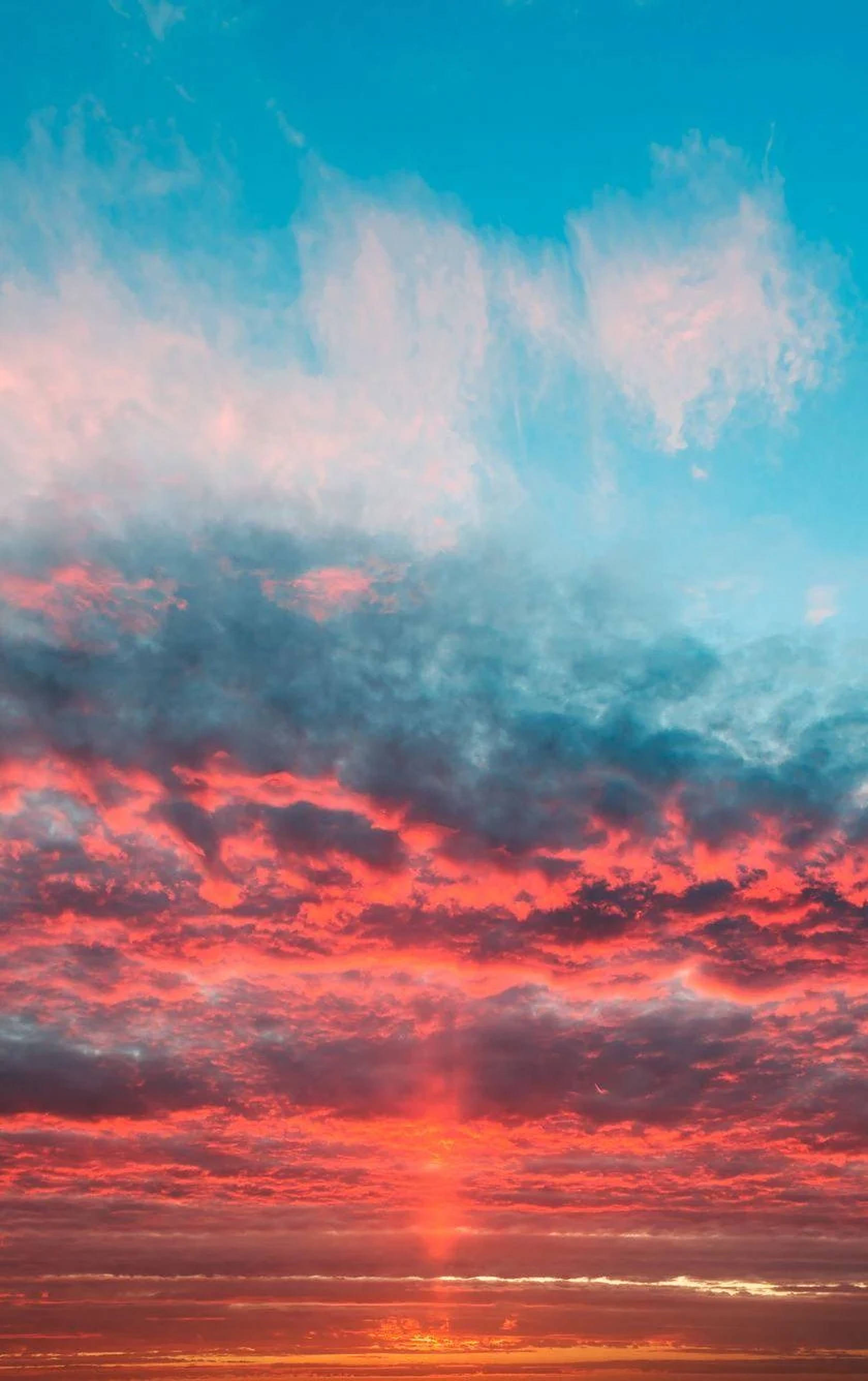 夕陽天空 桌布 壁紙 — 令人驚嘆的日落用火紅和橙色在深藍色的畫布上繪製天空，伴隨著縷縷薄雲。