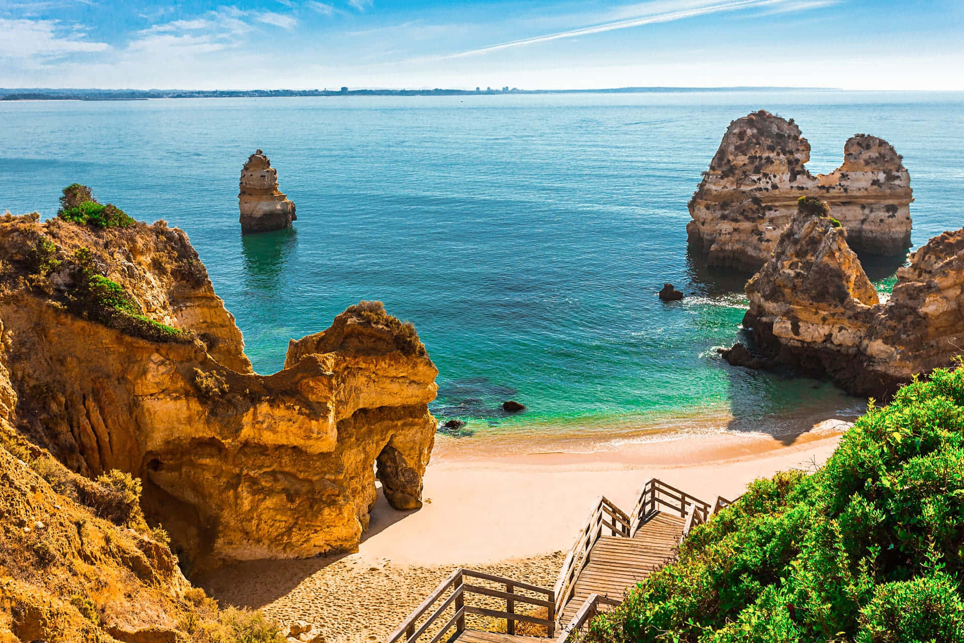 Portuguese Beach 桌布 壁紙 — 令人驚嘆的海岸景色，碧綠的海水、金色的懸崖和通往隱蔽沙灘的木樓梯。