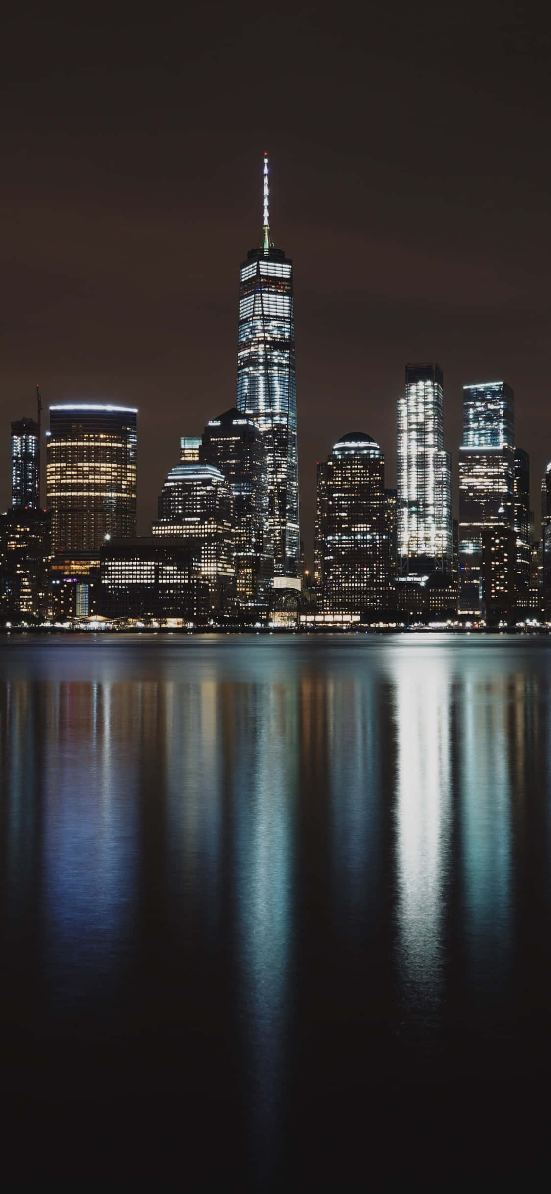 New York 桌布 壁紙 — 令人驚嘆的紐約天際線夜景，平靜的水面倒映著燈火輝煌的摩天大樓。