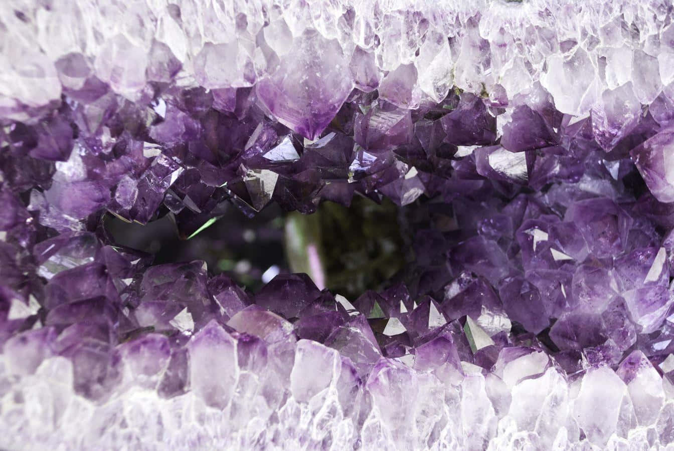 紫水晶 桌布 壁紙 — 令人驚嘆的紫水晶晶洞特寫，展現出閃閃發光的紫色晶體，中心有一個黑暗的空洞。