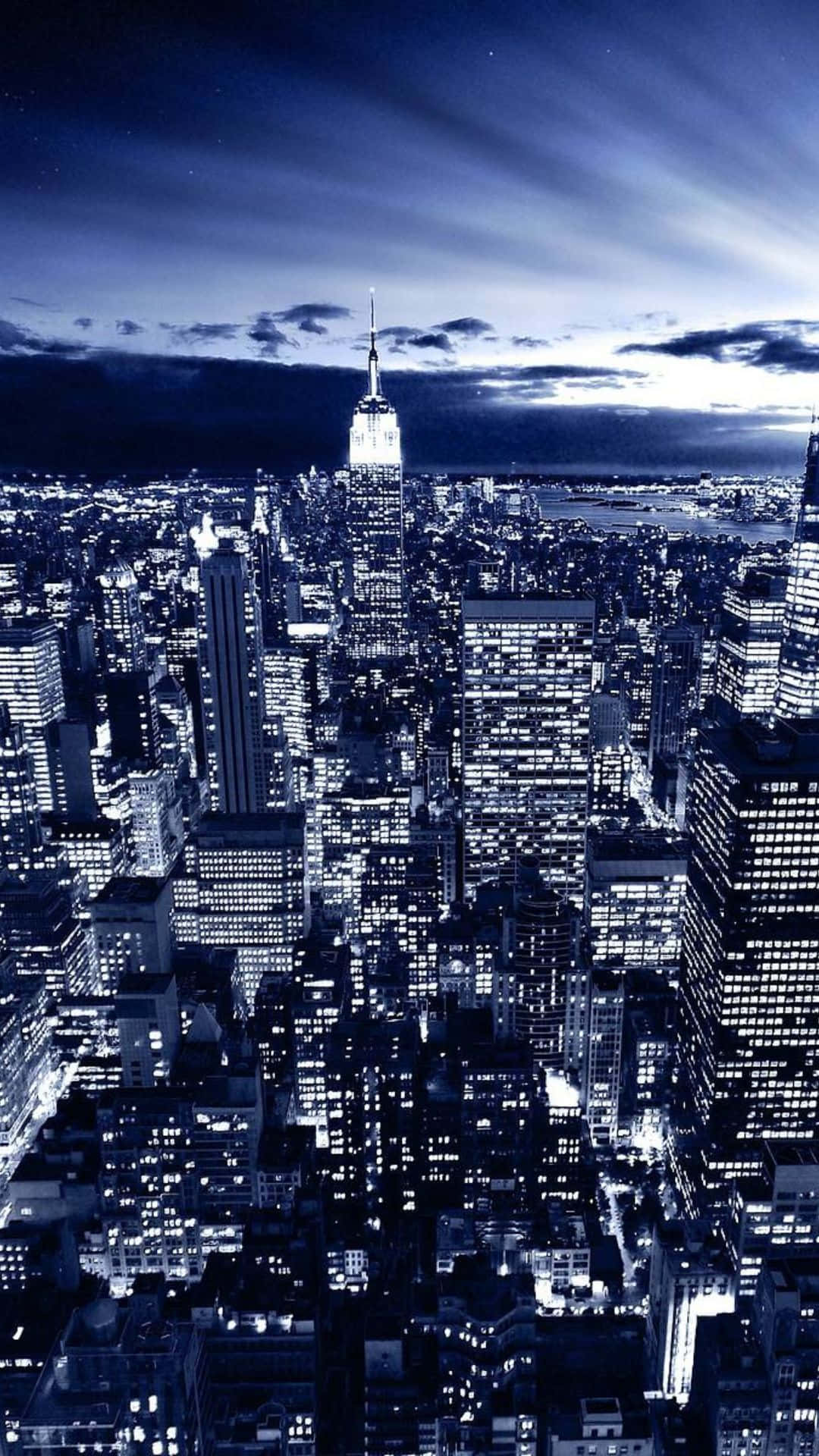Android Ny City 桌布 壁紙 — 令人驚嘆的藍色調紐約市夜景鳥瞰圖，帝國大廈在燈火通明的摩天大樓海洋上方閃耀。