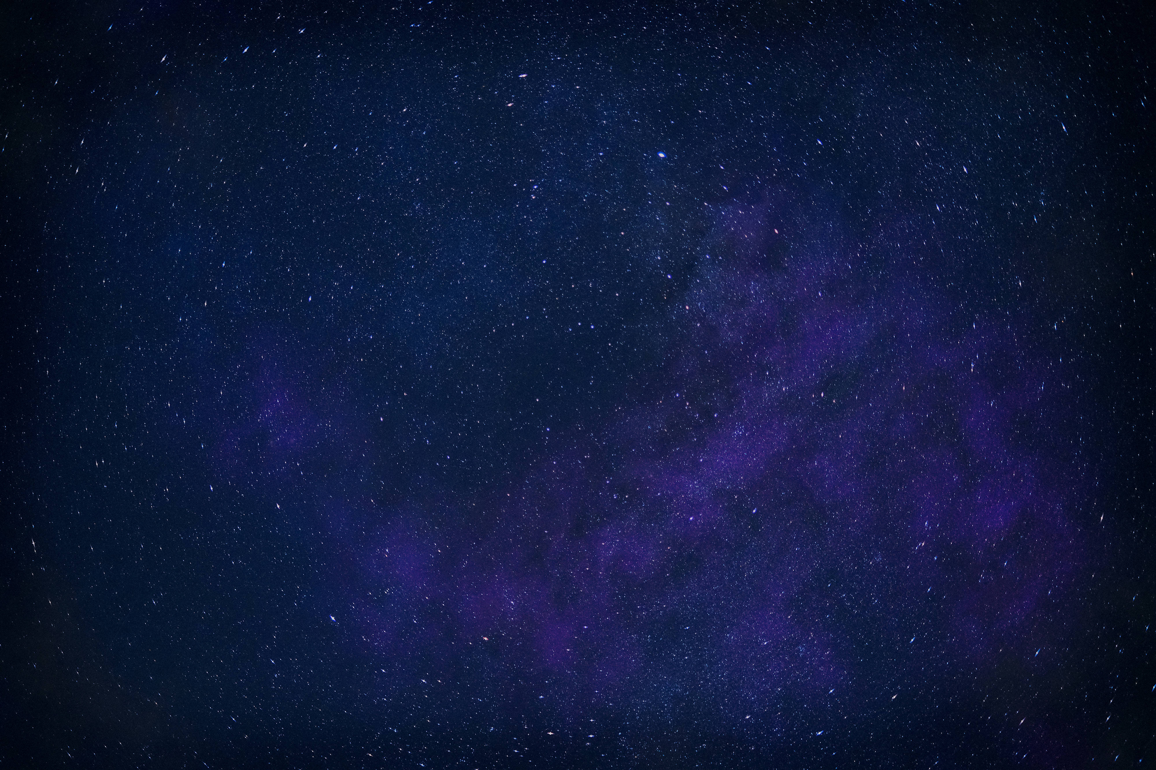 Blue And Purple Galaxy 桌布 壁紙 — 令人驚嘆的銀河系景觀，在繁星點點的夜空下散發出深紫色和靛藍色的光芒。