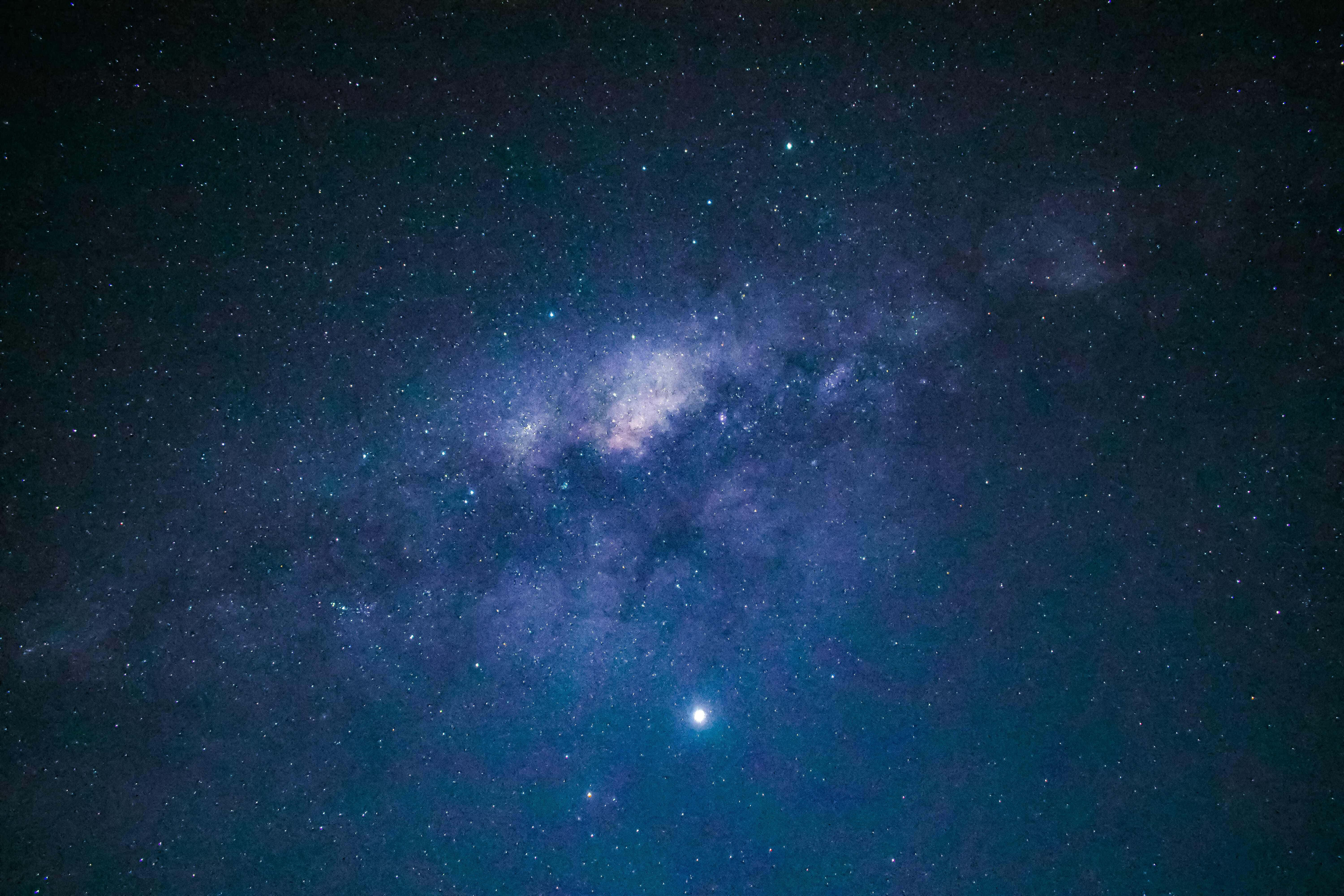 Blue Stars 桌布 壁紙 — 令人驚嘆的銀河系景觀，在繁星點點的夜空下閃耀著鮮豔的藍色和紫色。