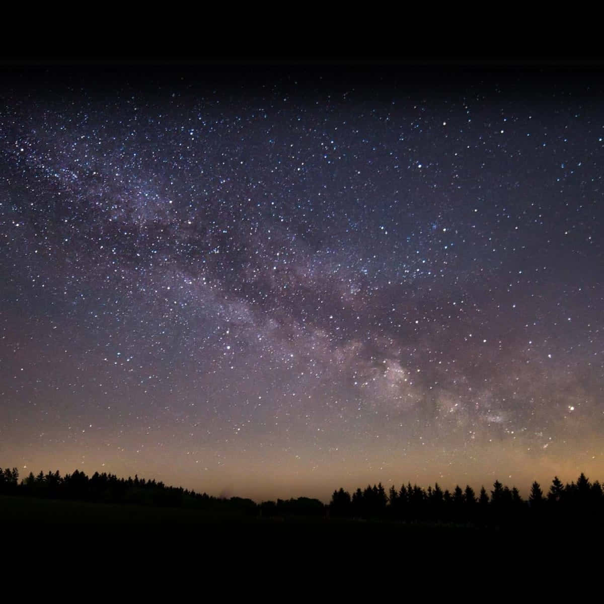 夜空 桌布 壁紙 — 令人驚嘆的銀河系景觀，在黑暗森林剪影上方，橫跨滿天繁星的夜空。