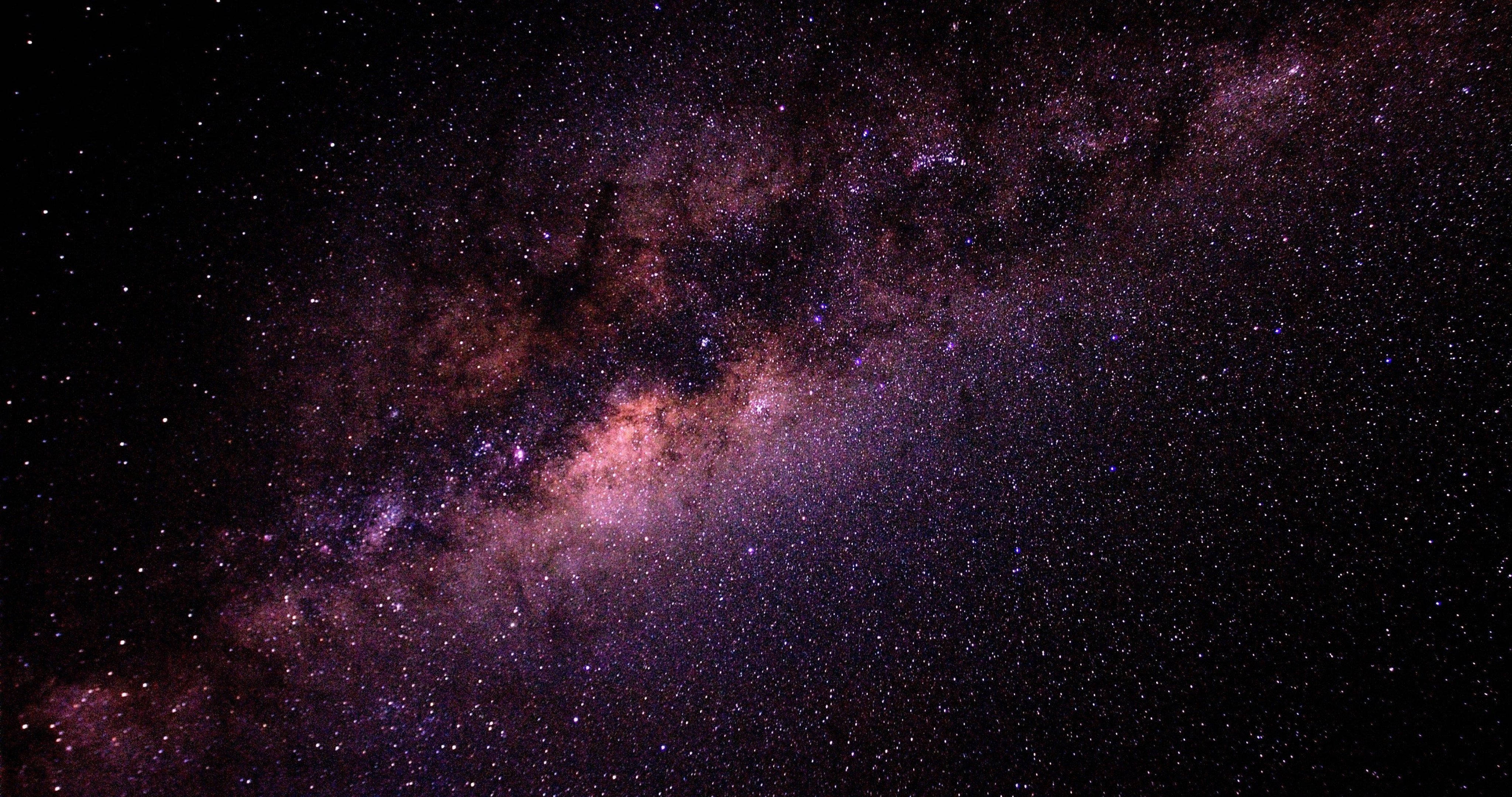 4K ultra HD galaxy 桌布 壁紙 — 令人驚嘆的銀河系景觀，紫色和粉色的宇宙塵埃在繁星點點的夜空中閃耀。