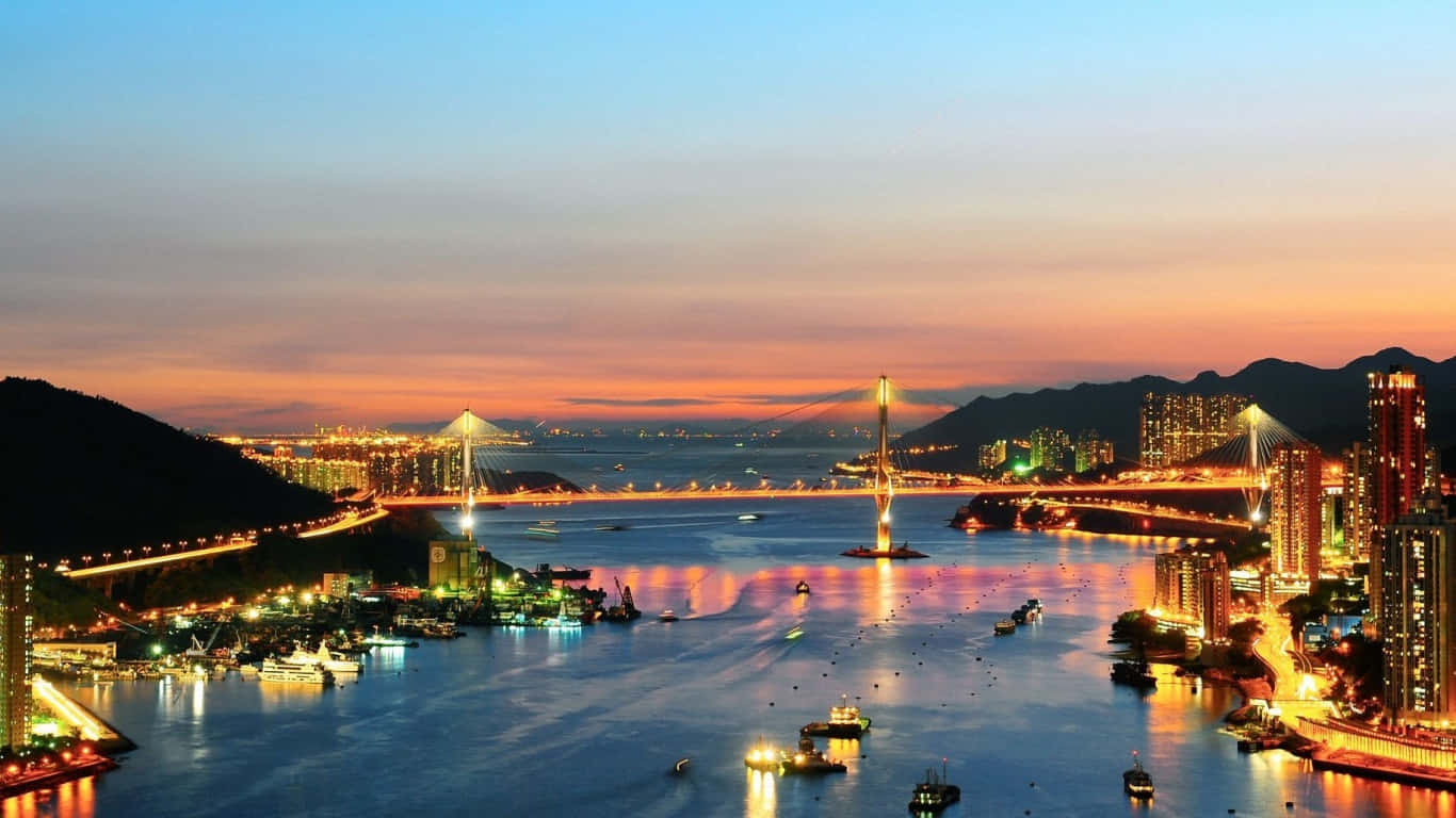 1366x768 San Francisco 桌布 壁紙 — 令人驚嘆的黃昏城市景觀，燈火通明的橋樑和摩天大樓倒映在被山丘環繞的平靜水面上。