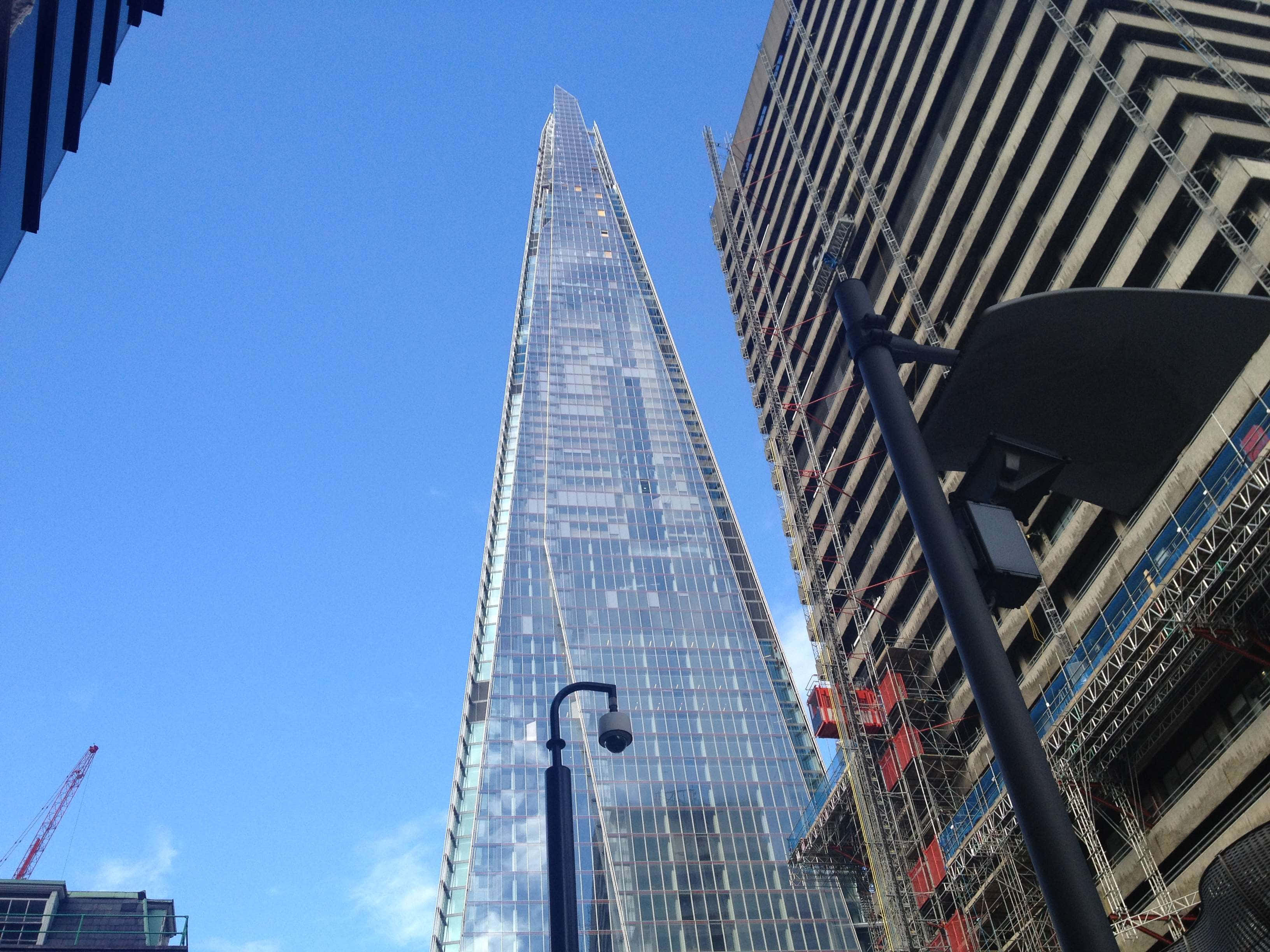 England 桌布 壁紙 — 以低角度觀看標誌性的碎片大廈刺穿清澈的藍天，兩旁有建築鷹架和路燈。