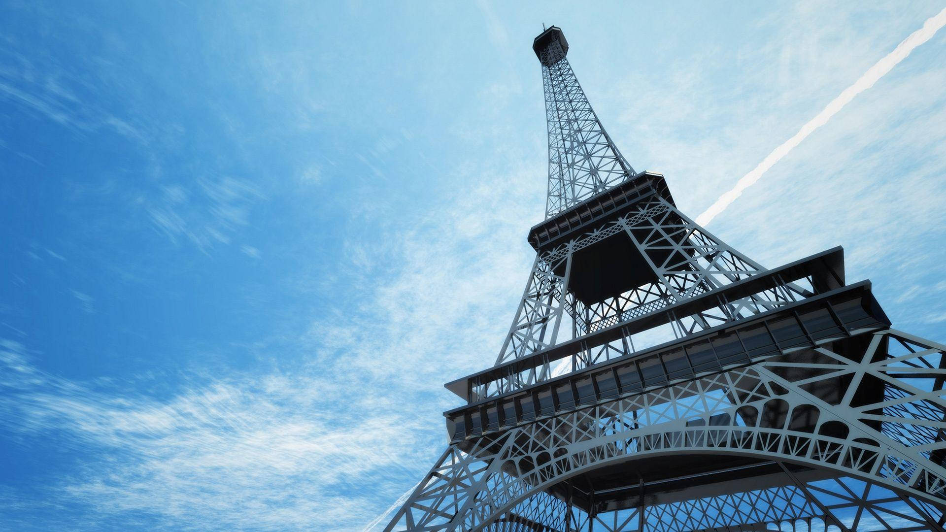 Paris Eiffel Tower 桌布 壁紙 — 以低角度觀賞艾菲爾鐵塔複雜的鐵製格子結構，背景是明亮藍天和縷縷白雲。