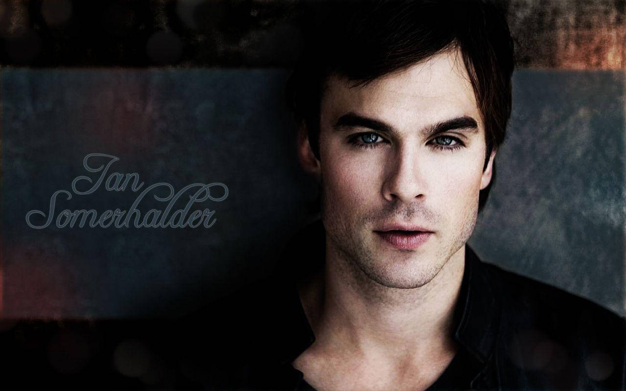 Damon Salvatore 桌布 壁紙 — 伊恩·桑默海爾德的近距離肖像，擁有強烈的藍色眼睛和深色頭髮，背景帶有紋理且充滿氛圍。