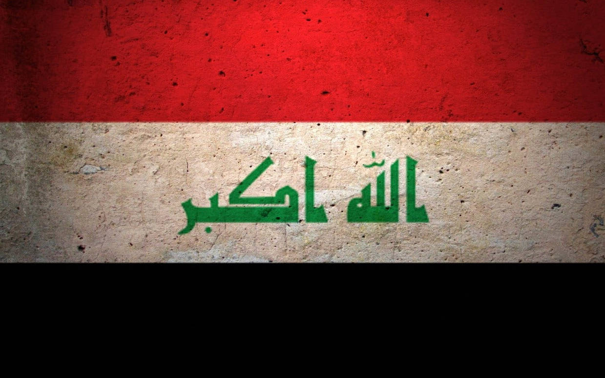 Iraq 桌布 壁紙 — 伊拉克國旗繪在風化的混凝土牆上，有紅、白、黑條紋和綠色阿拉伯文字。
