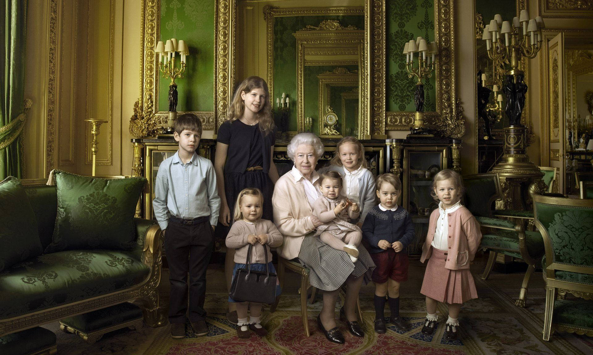 Queen Elizabeth 桌布 壁紙 — 伊莉莎白二世女王端莊地坐在一個鍍金的房間裡，被穿著正式服裝的孫輩們圍繞。