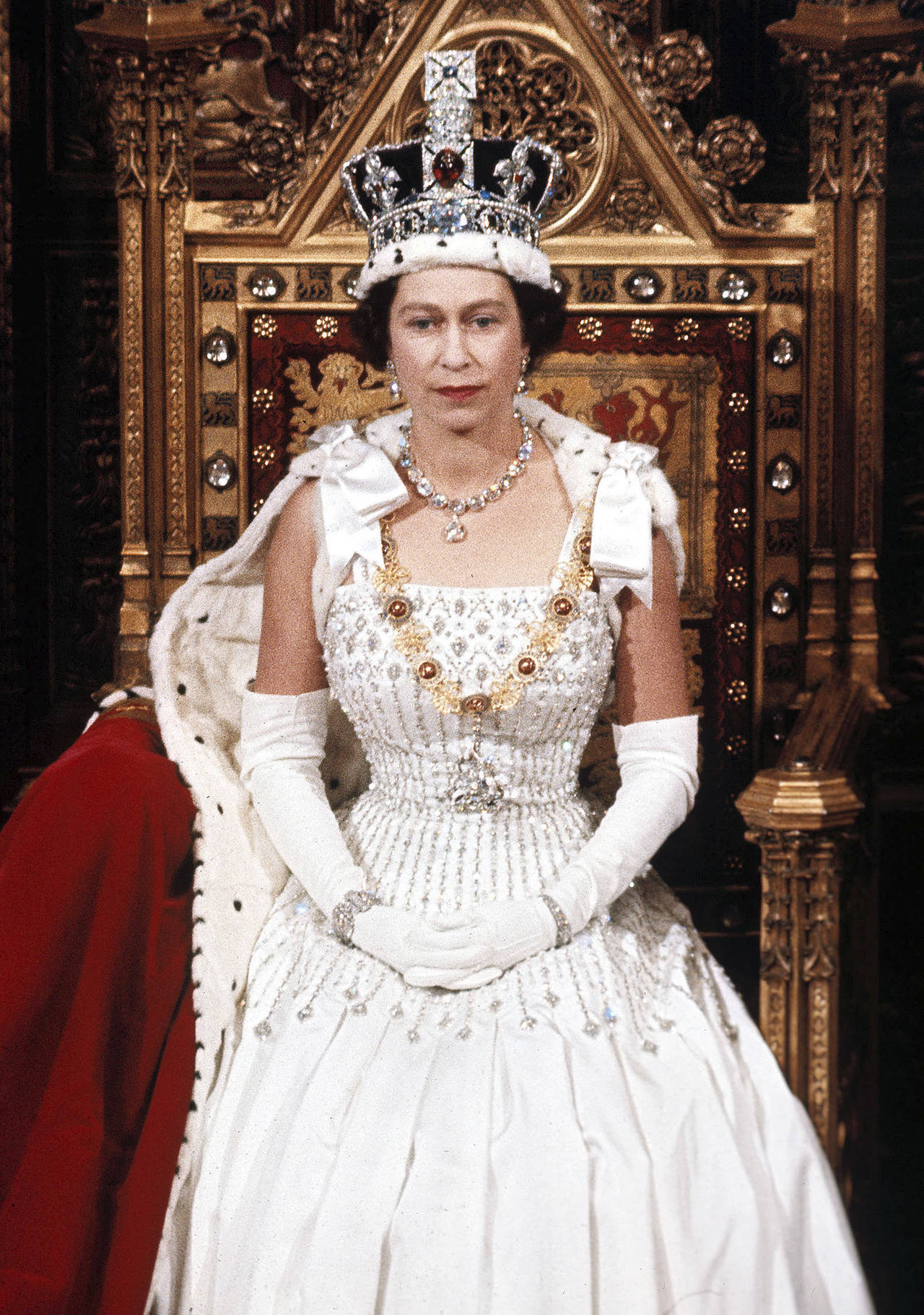 Queen Elizabeth 桌布 壁紙 — 伊莉莎白二世女王端莊地坐在鍍金王座上，佩戴鑲有珠寶的王冠、白色貂皮鑲邊長袍和鑽石項鍊。