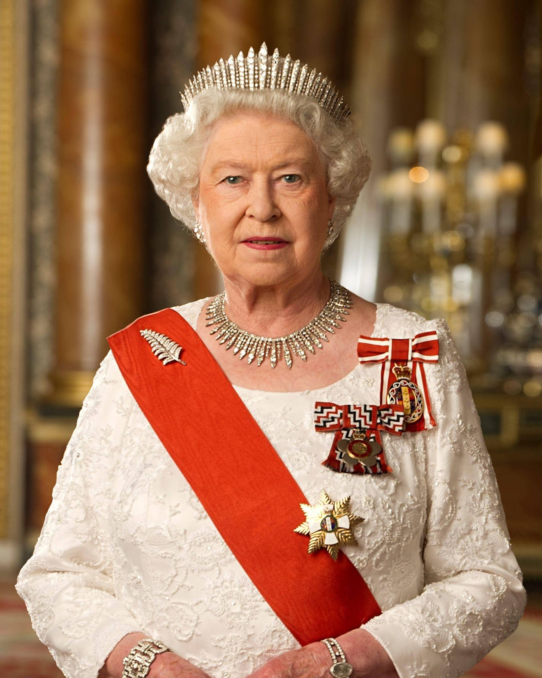 Queen Elizabeth 桌布 壁紙 — 伊莉莎白二世女王身穿正式禮服，佩戴鑽石头飾、紅色肩帶和華麗勳章，背景是鍍金宮殿。