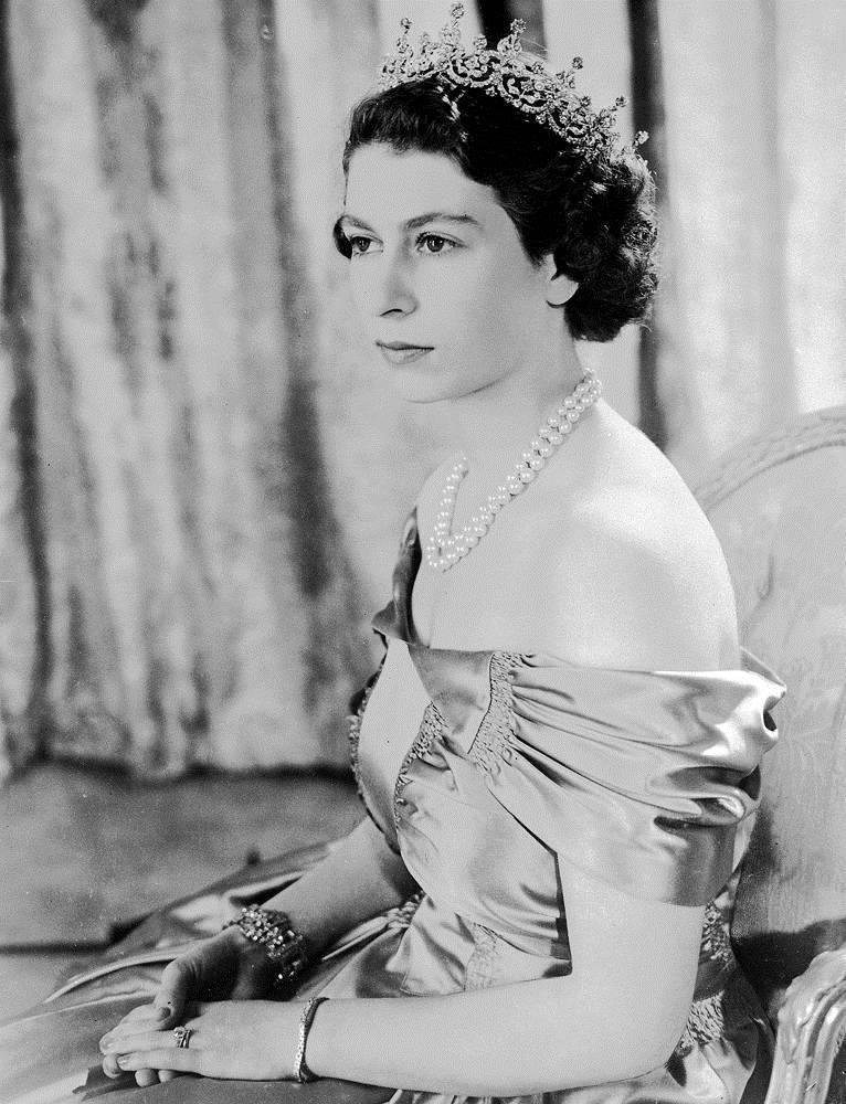 Queen Elizabeth 桌布 壁紙 — 伊莉莎白二世女王身穿正裝，佩戴后冠和珍珠項鍊，端坐的莊嚴黑白肖像。